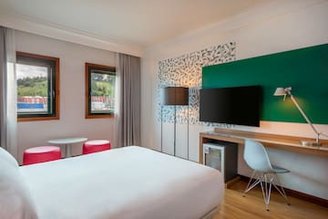 a room with a bed and a television