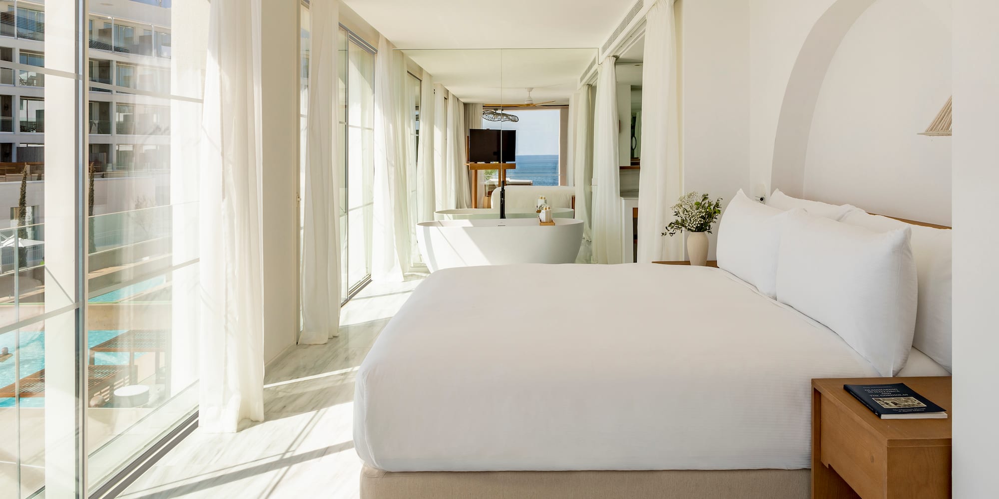 a bedroom with a large bed and a bathtub