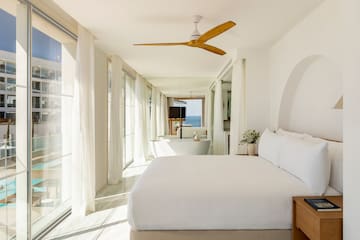 a bedroom with a large bed and a bathtub