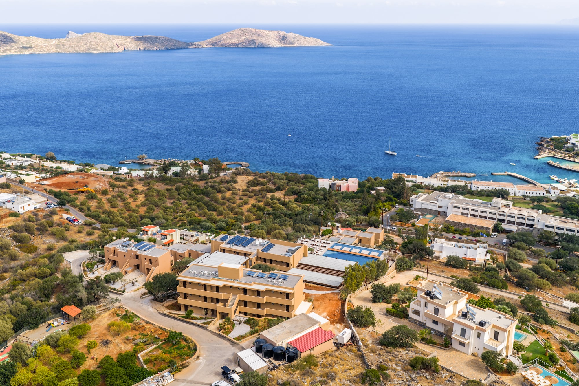 Aerial view: Mediterranean coastal resort, sea, islands, hotels, and villas.