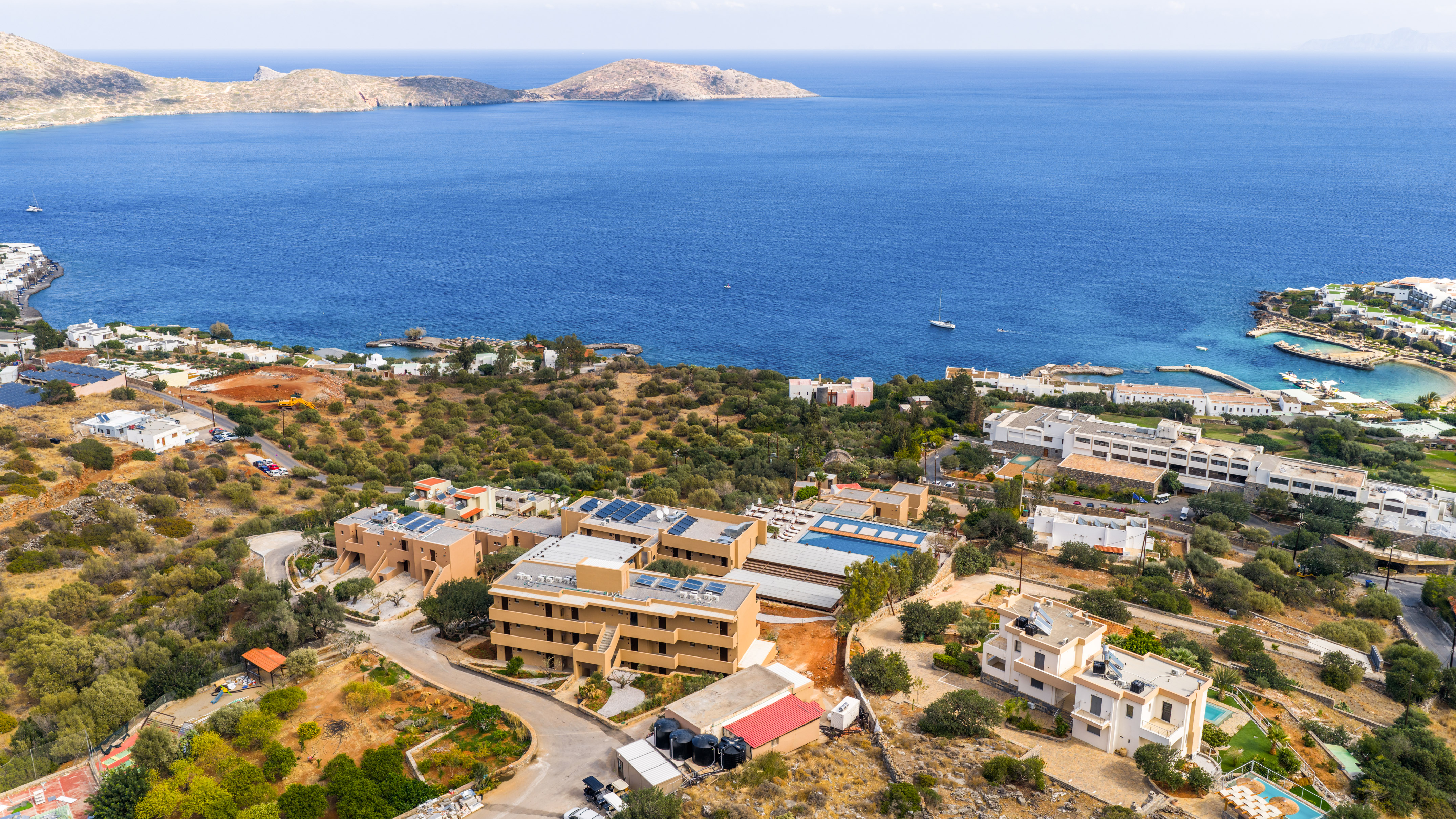 Aerial view: Mediterranean coastal resort, sea, islands, hotels, and villas.