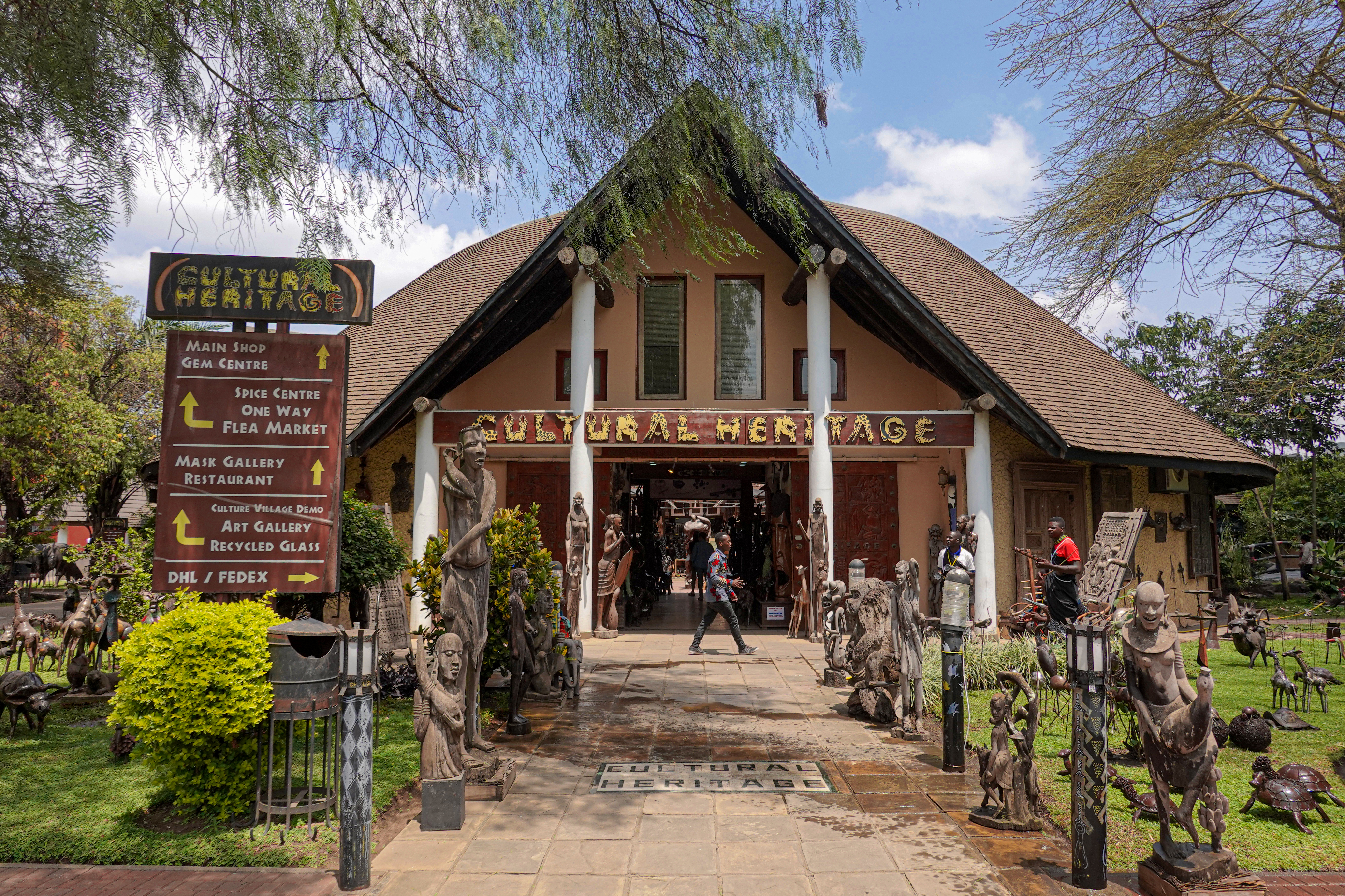 Cultural Heritage building entrance lined with African art sculptures.