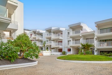 a white building with trees and grass