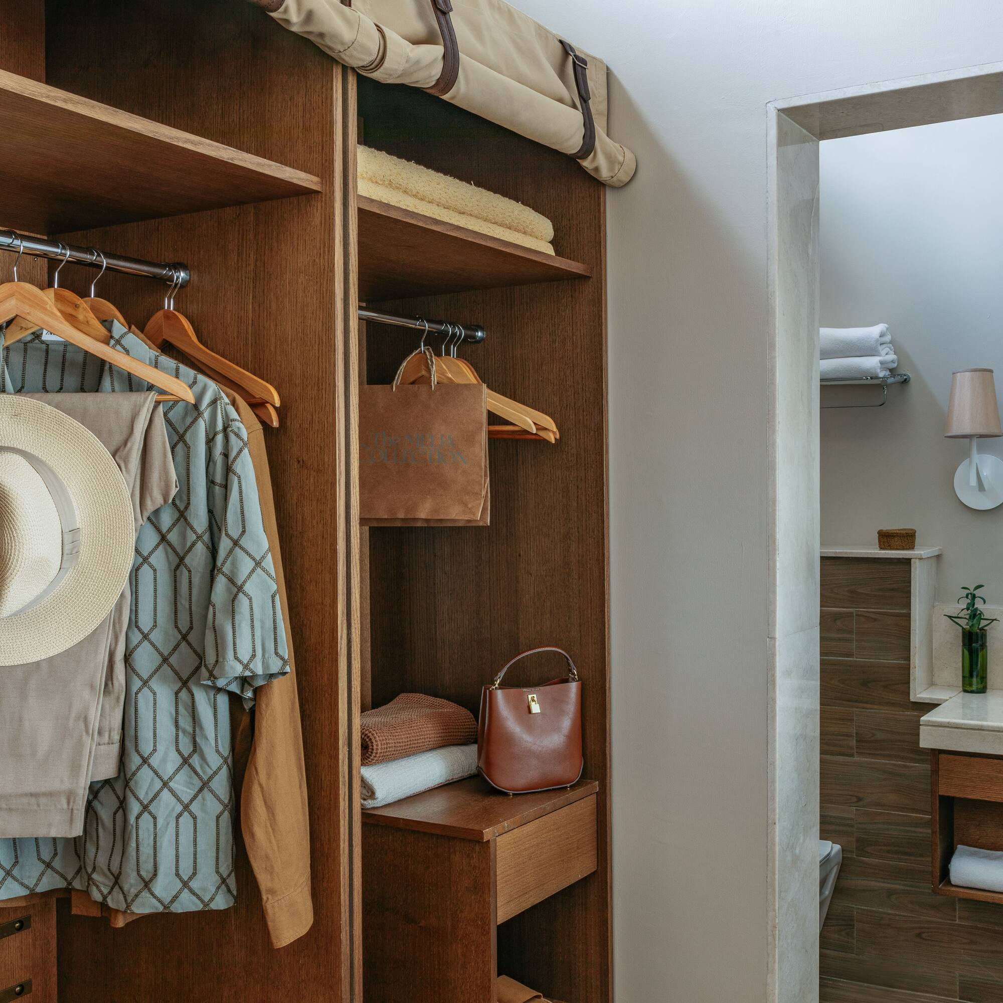 a closet with clothes on swingers and a towel