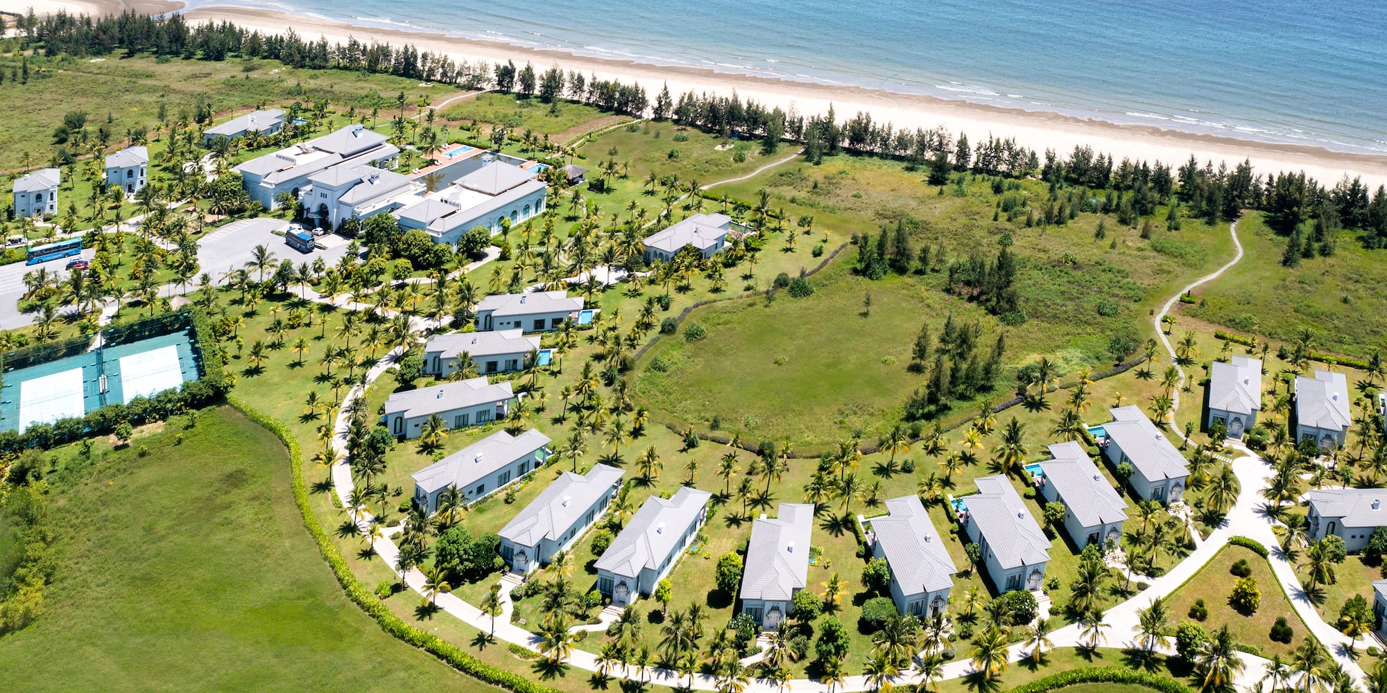 a group of houses in a circle surrounded by grass and trees
