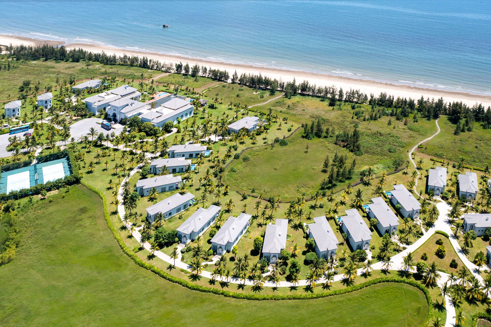 a group of houses in a circle surrounded by grass and trees