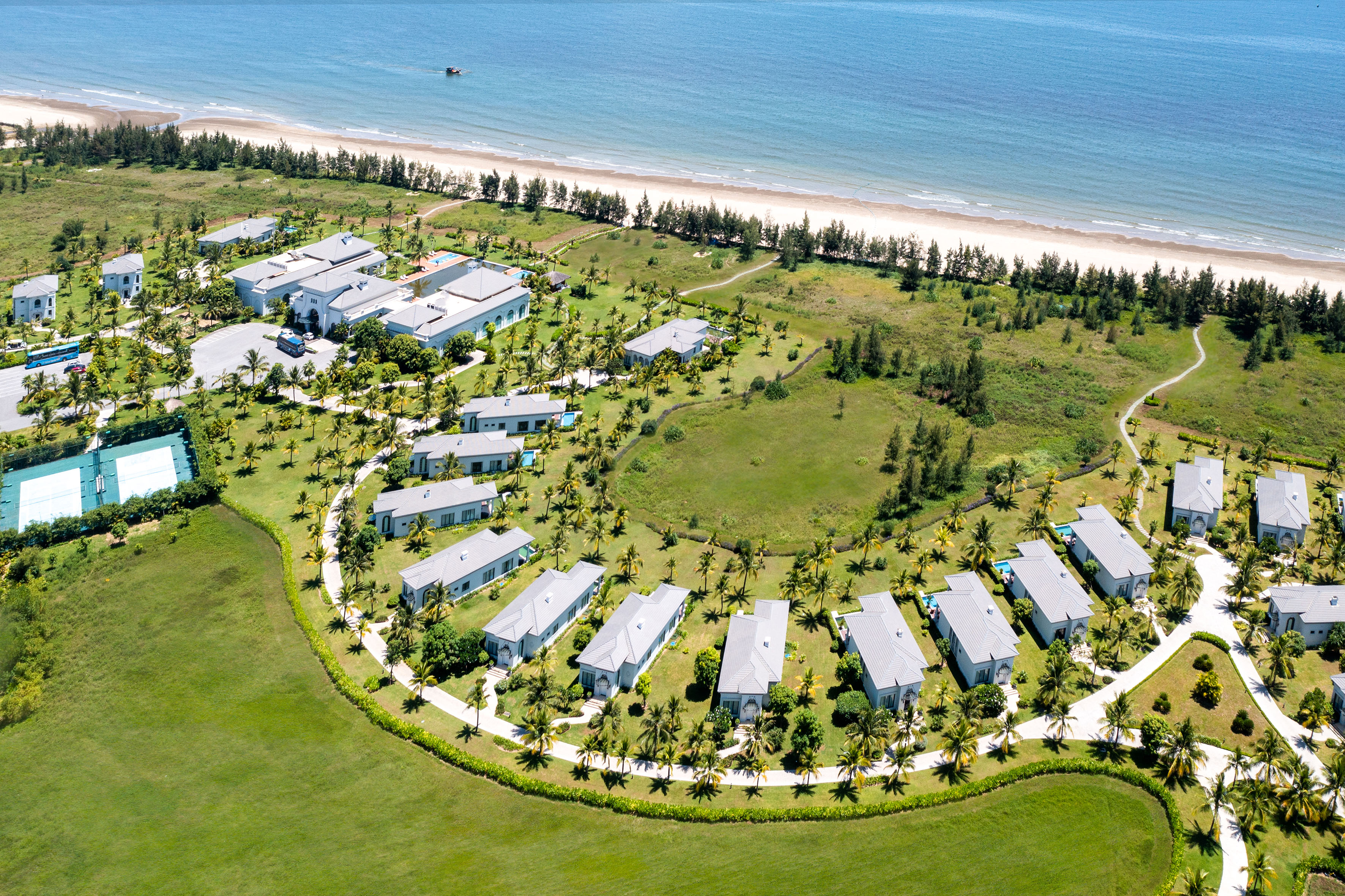 a group of houses in a circle surrounded by grass and trees