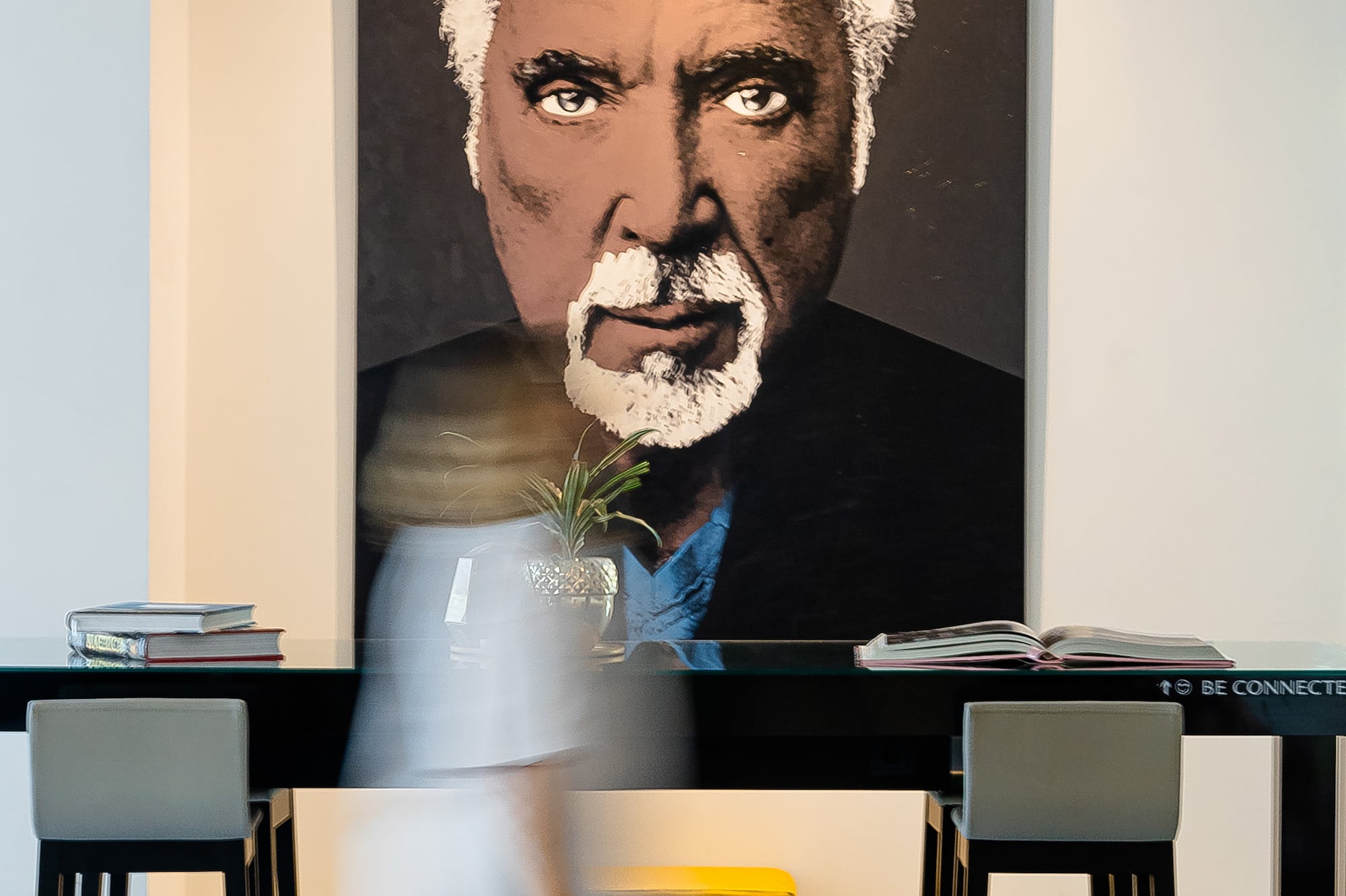 Tom Jones pop art portrait in a modern bar area with high stools.