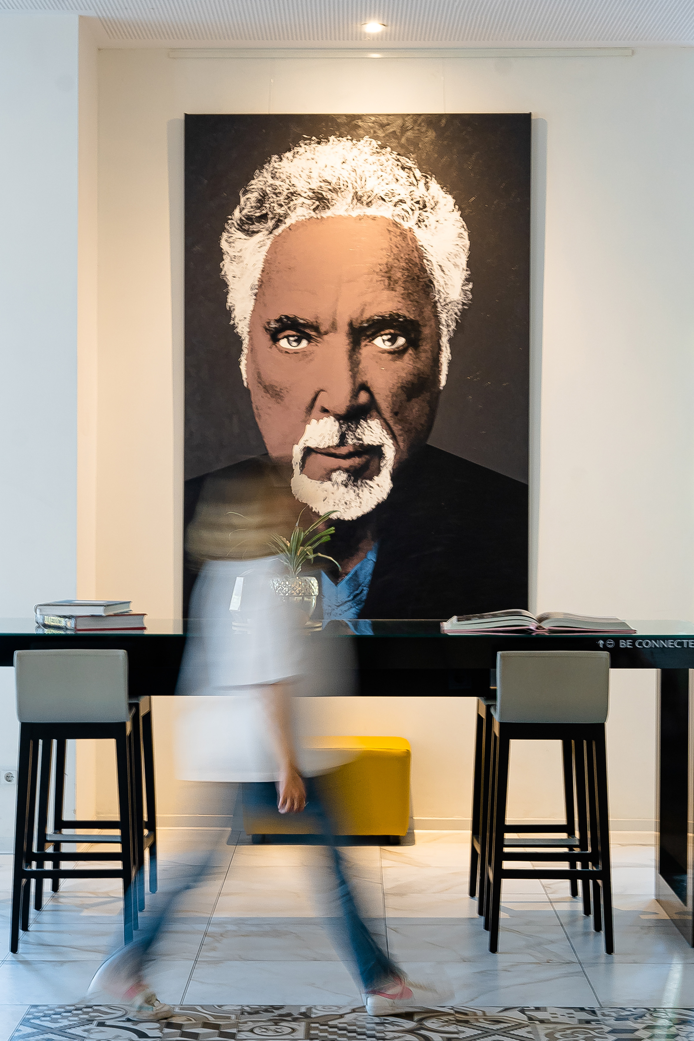 a person walking in front of a painting of a man