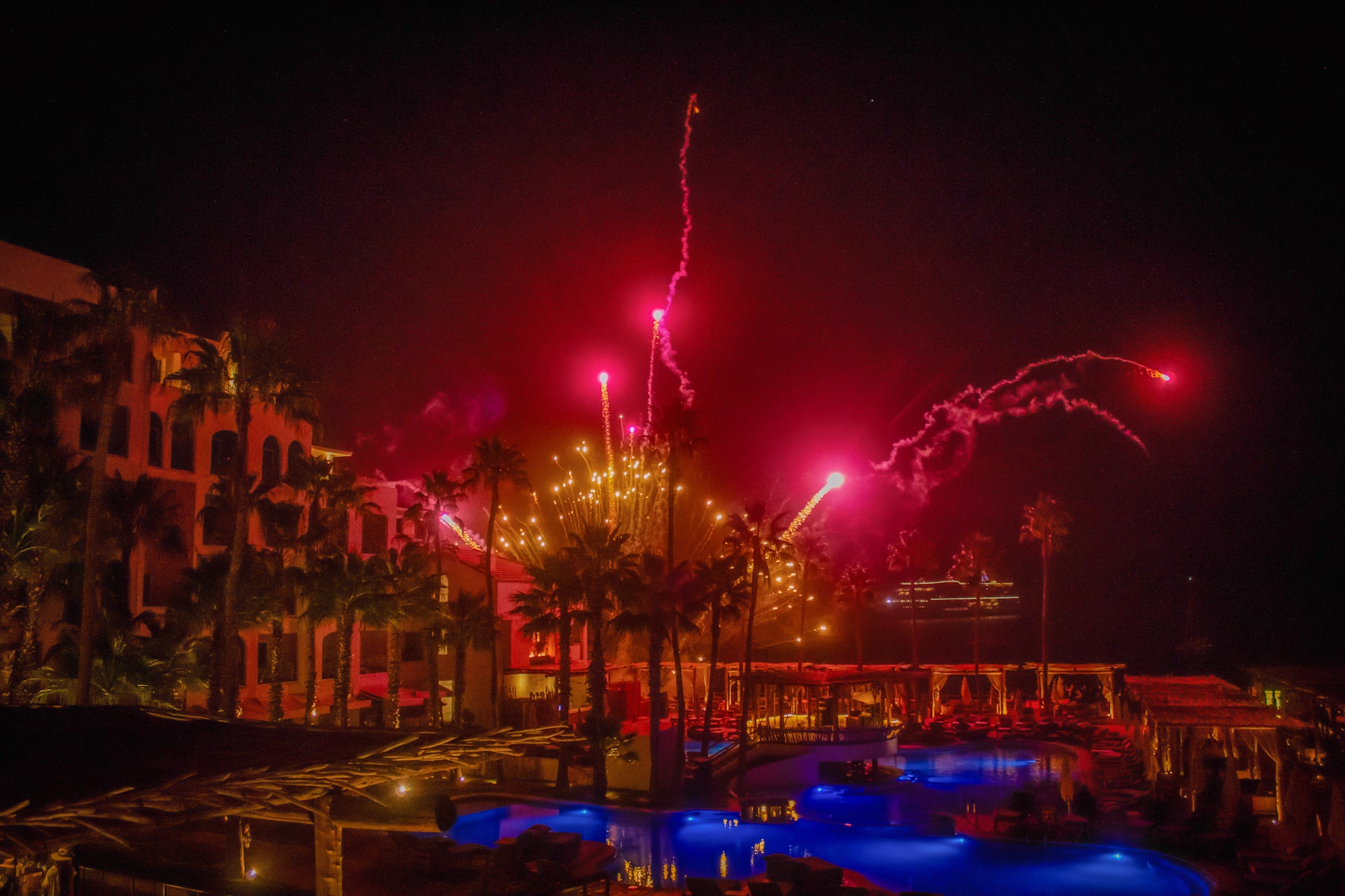 fireworks in the sky over a pool