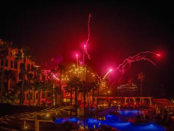 fireworks in the sky over a pool