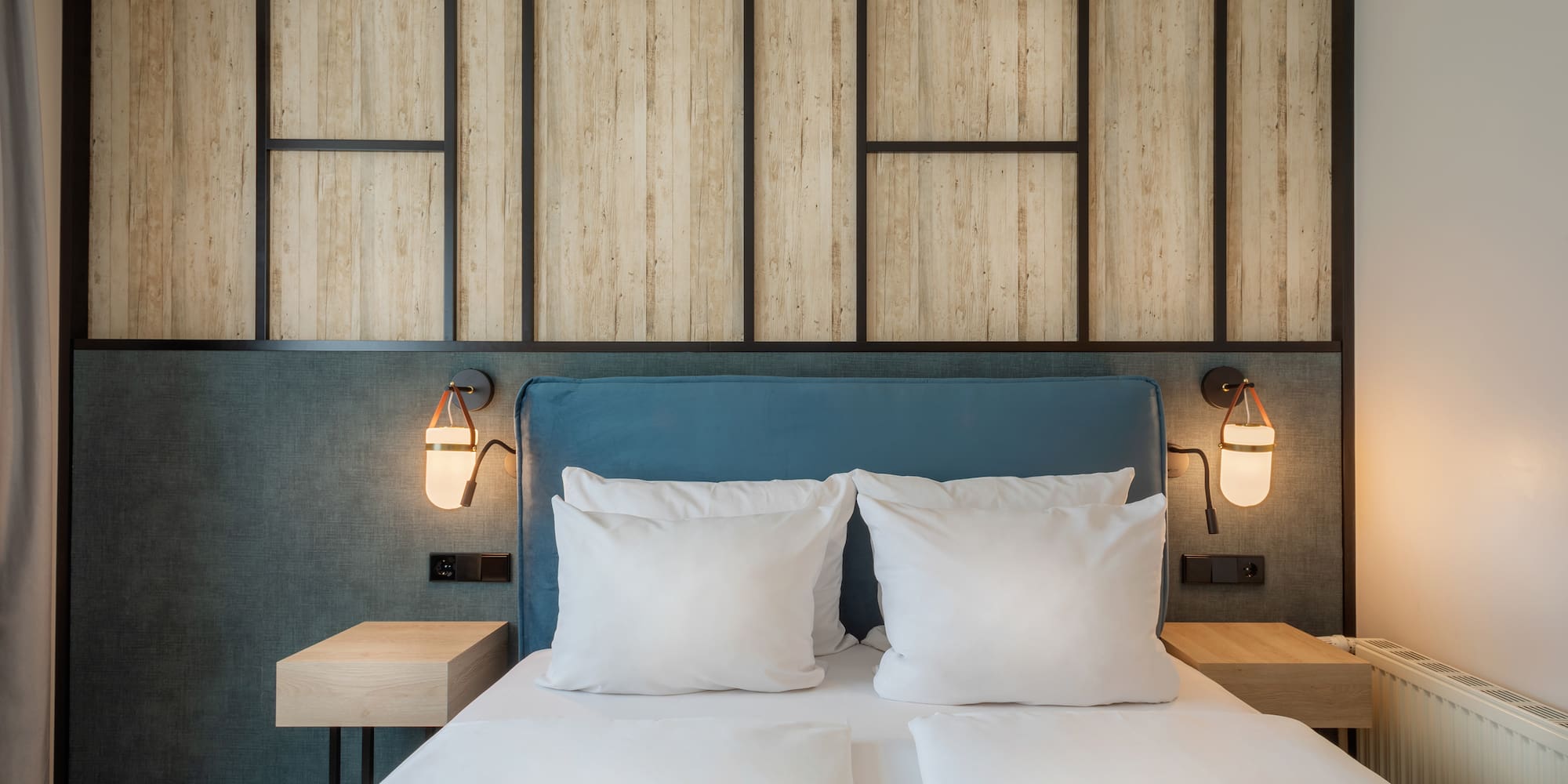 a bed with white pillows and a blue headboard