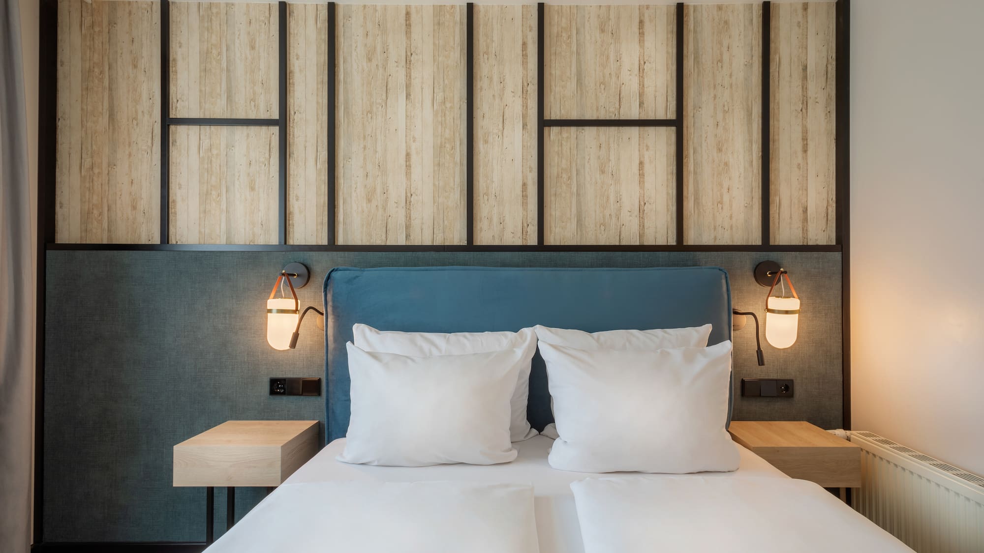 a bed with white pillows and a blue headboard