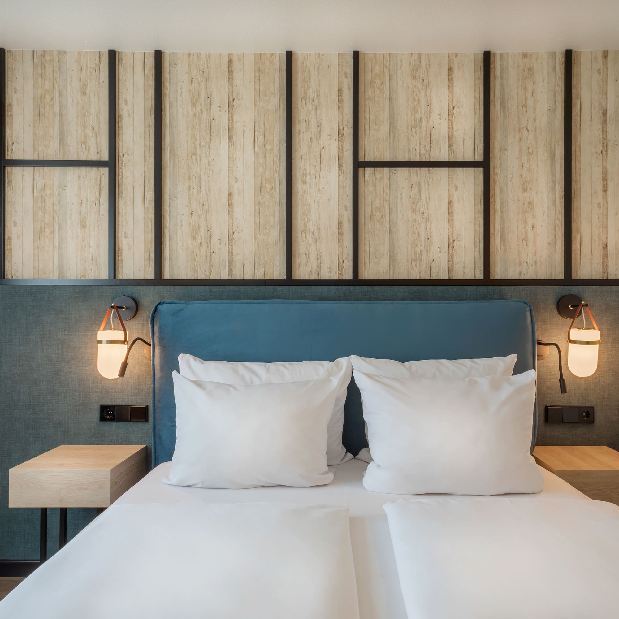 a bed with white pillows and a blue headboard