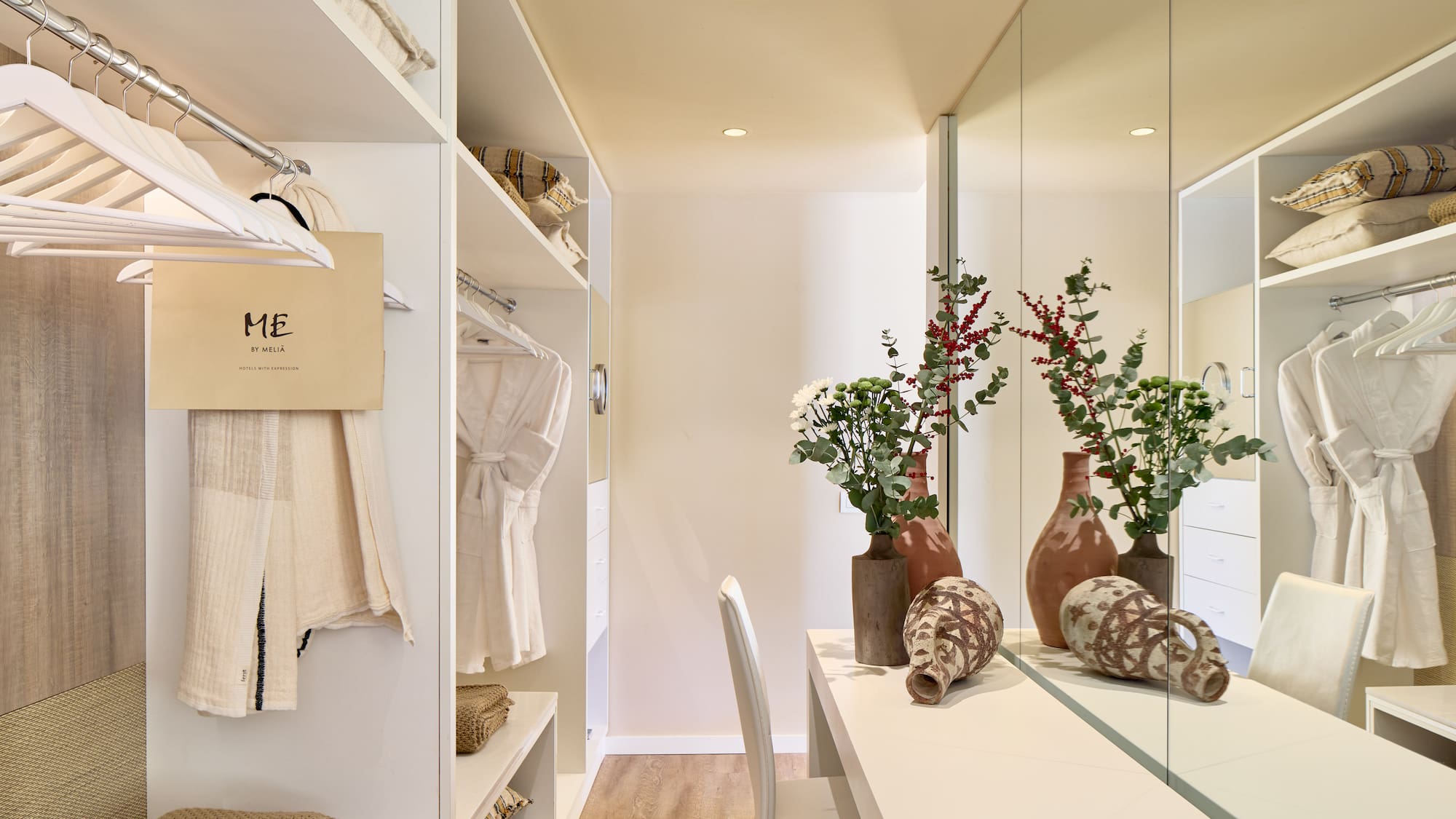 a room with a mirror and shelves with vases and flowers