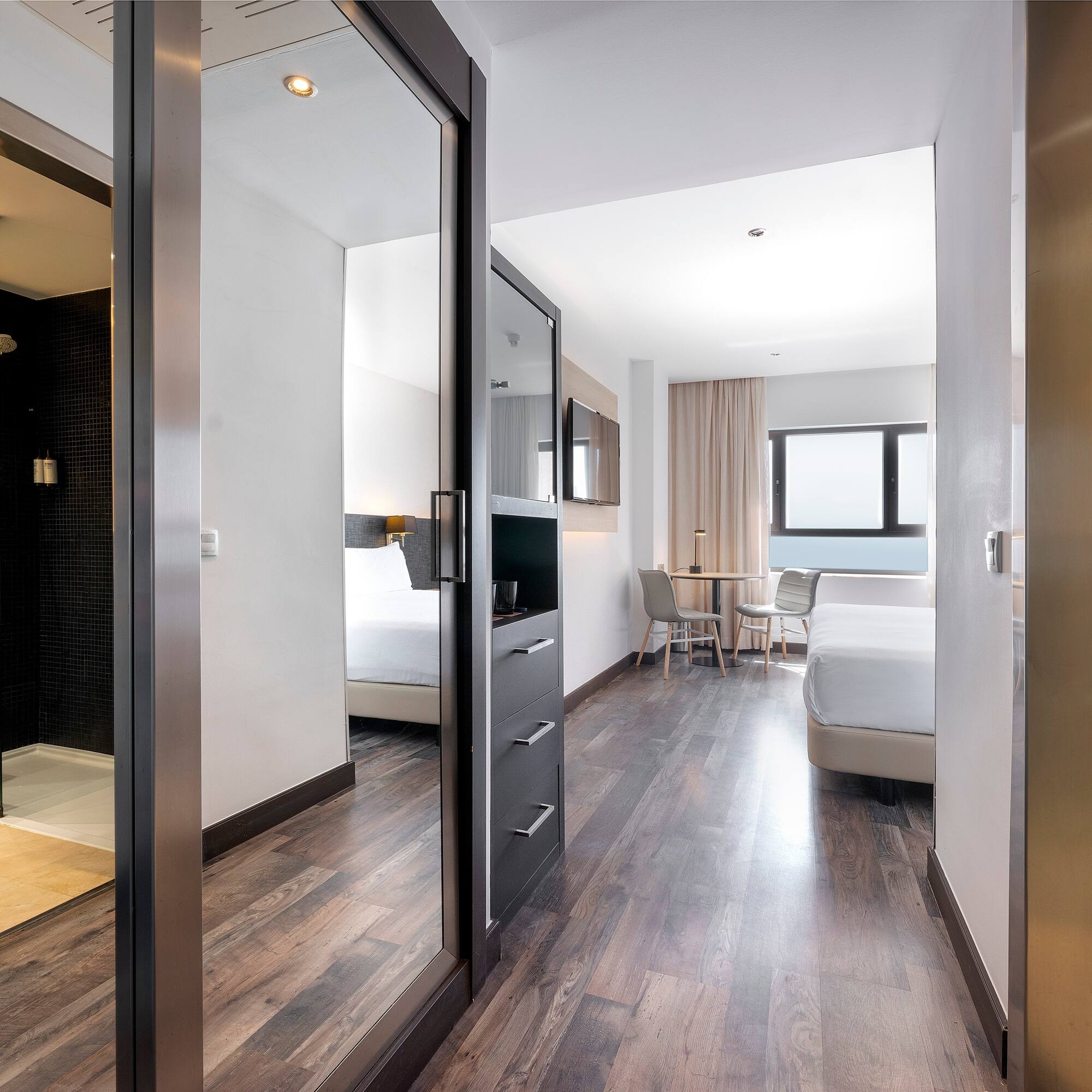 a room with a mirror door and a bed