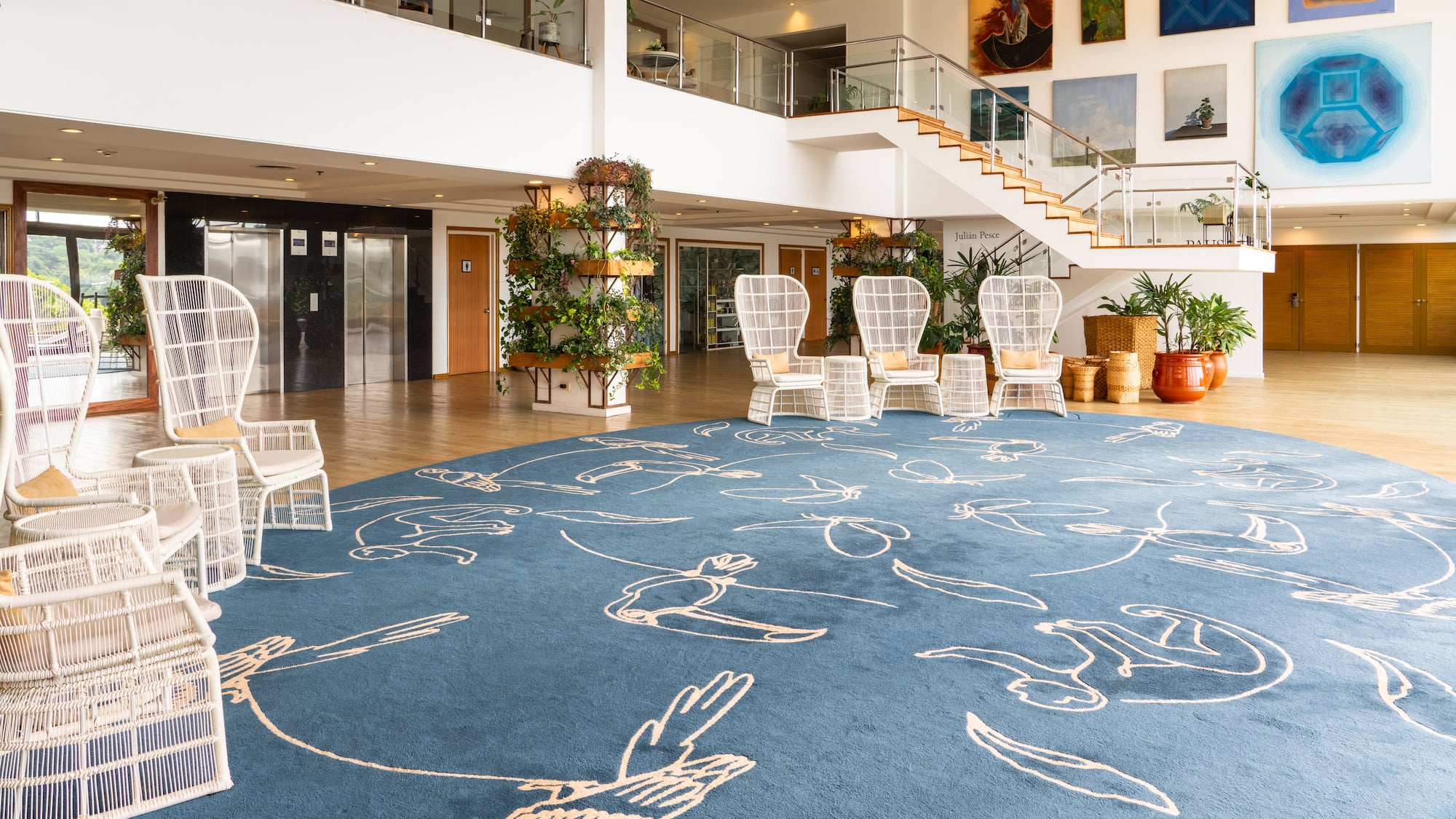 a large room with a blue carpet and white chairs