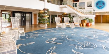 a large room with a blue carpet and white chairs