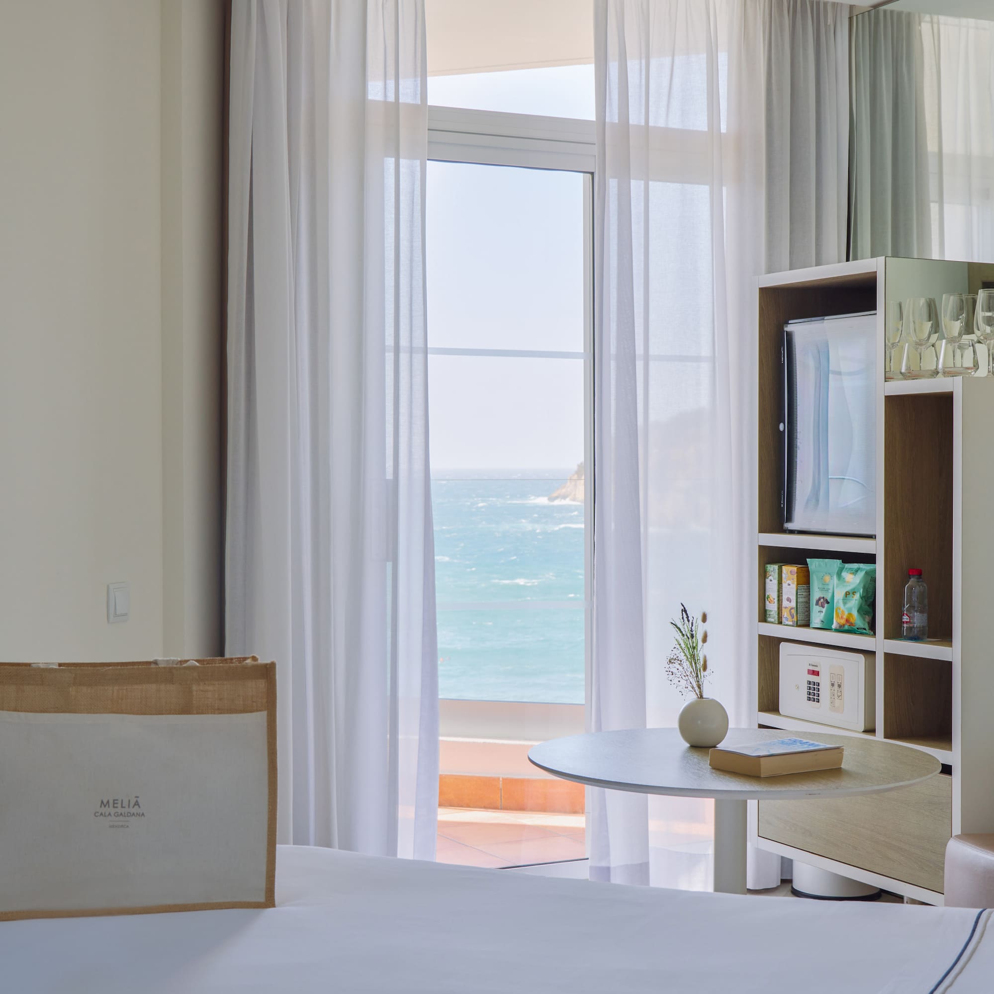 a room with a bed and a table and a bookcase