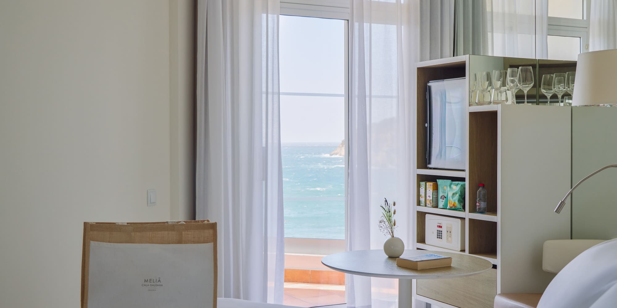 a room with a bed and a table and a bookcase