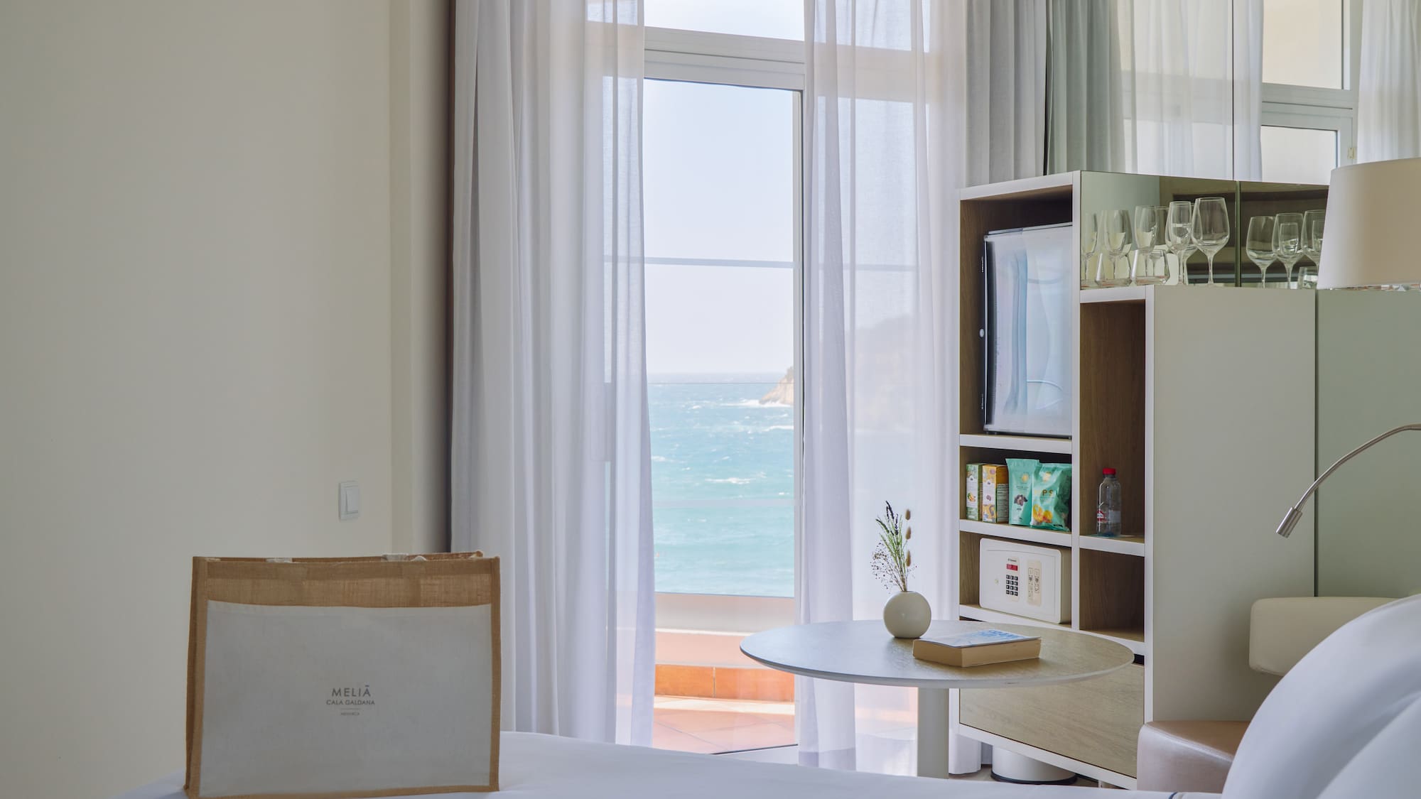 a room with a bed and a table and a bookcase