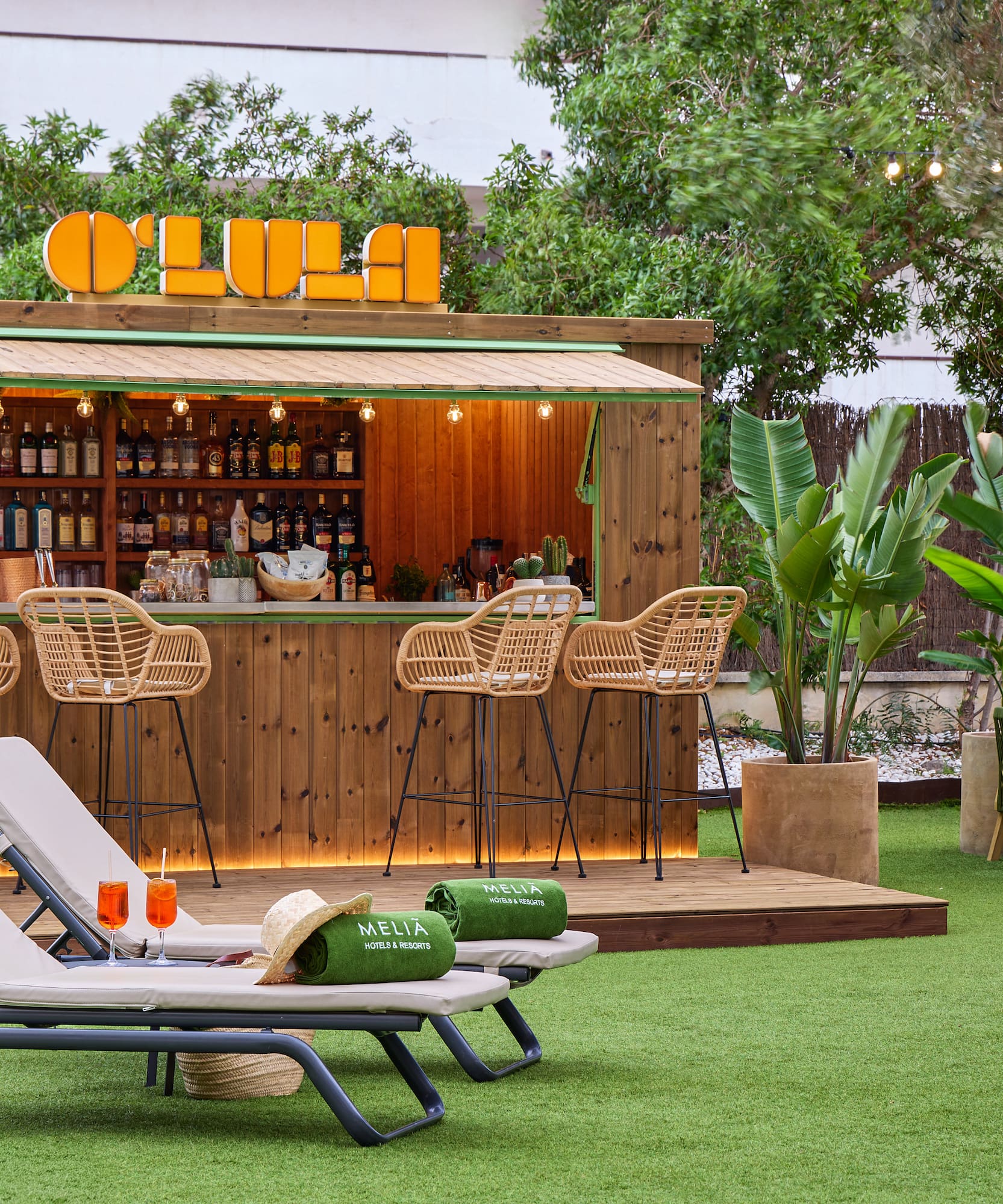 Tropical outdoor bar, lounge chairs, cocktails, green grass, Meliá resort.