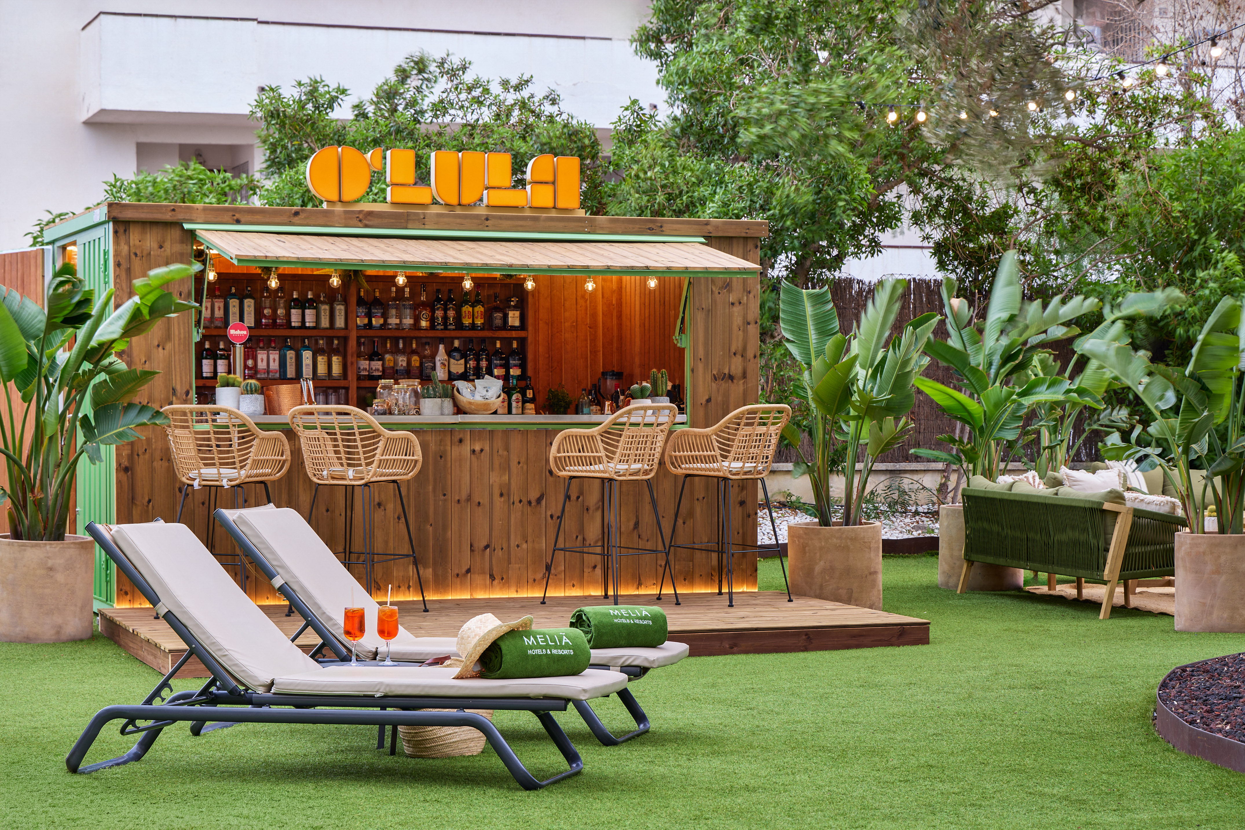 Tropical outdoor bar, lounge chairs, cocktails, green grass, Meliá resort.
