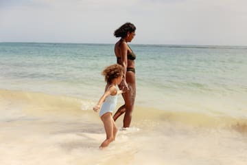 a woman and a child walking in the water