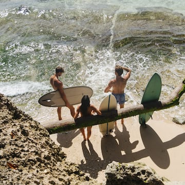 a group of people holding surfboards on a beach
