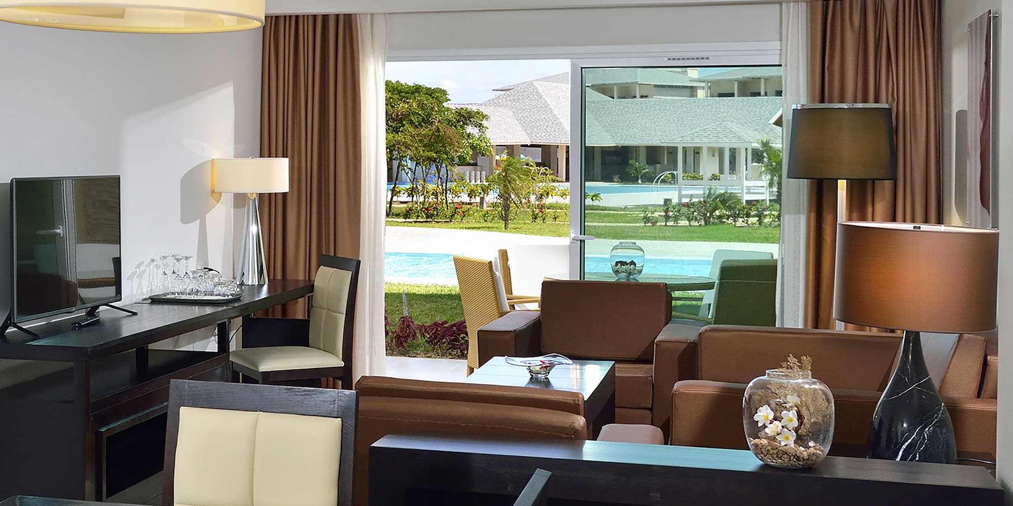 a room with a table and chairs and a pool outside