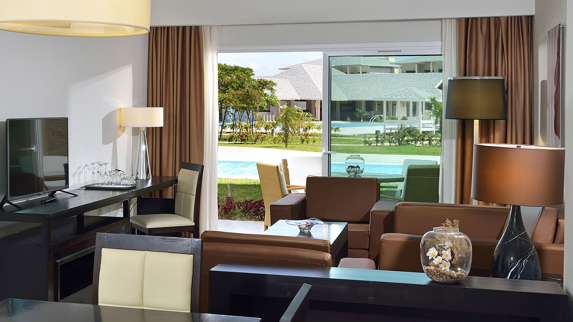 a room with a table and chairs and a pool outside