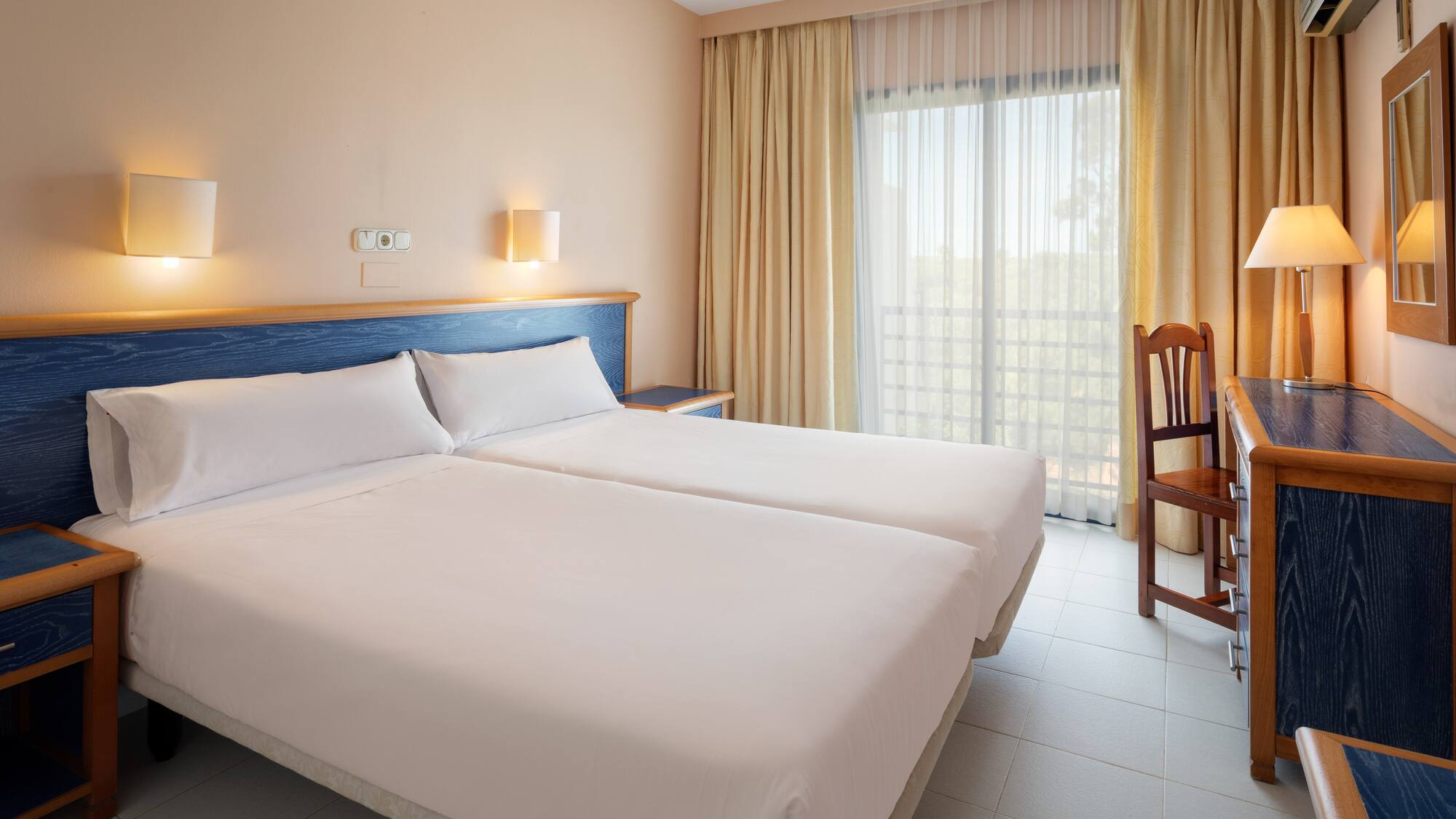 a room with two beds and a chair