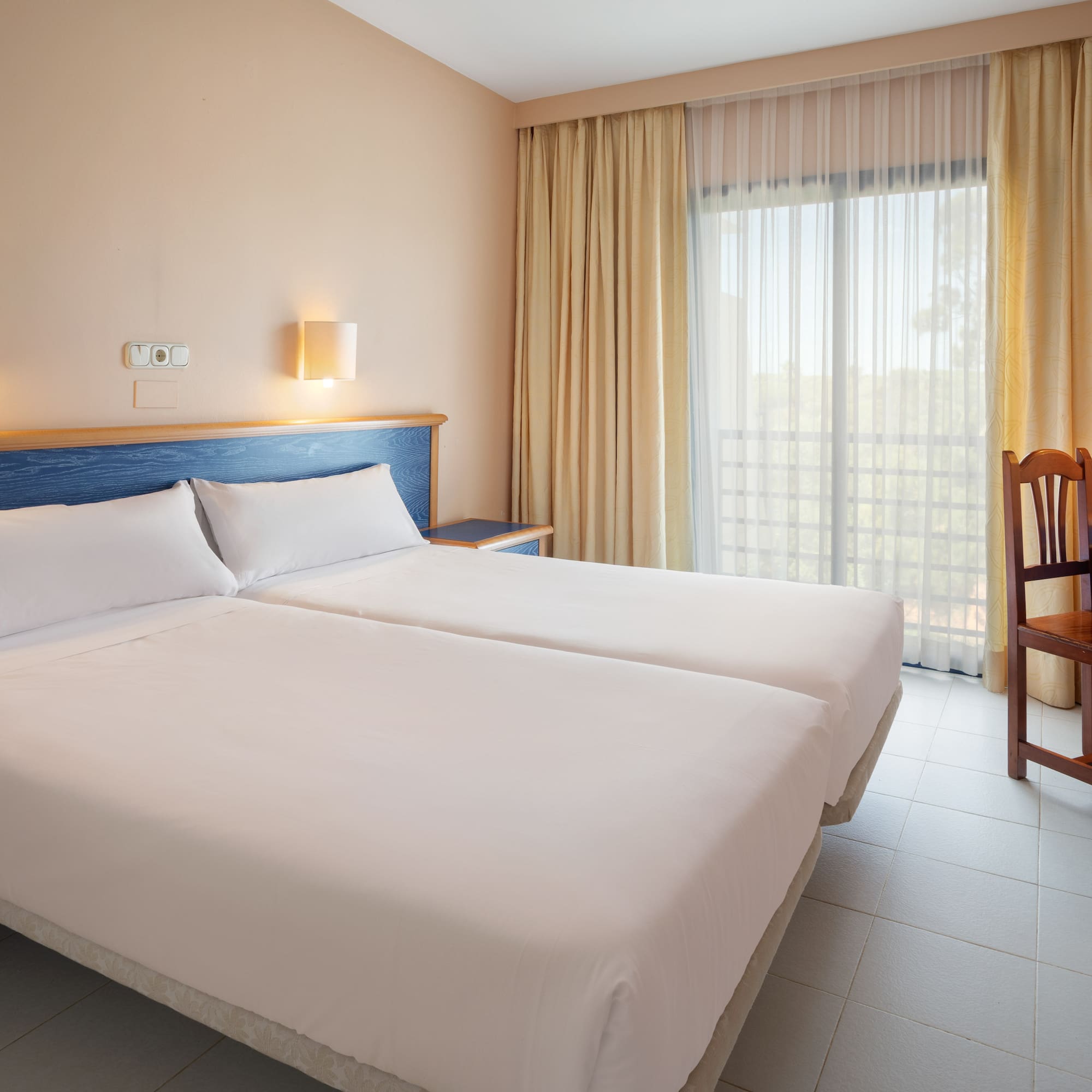 a room with two beds and a chair