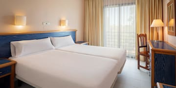 a room with two beds and a chair