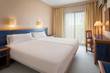 a room with two beds and a chair