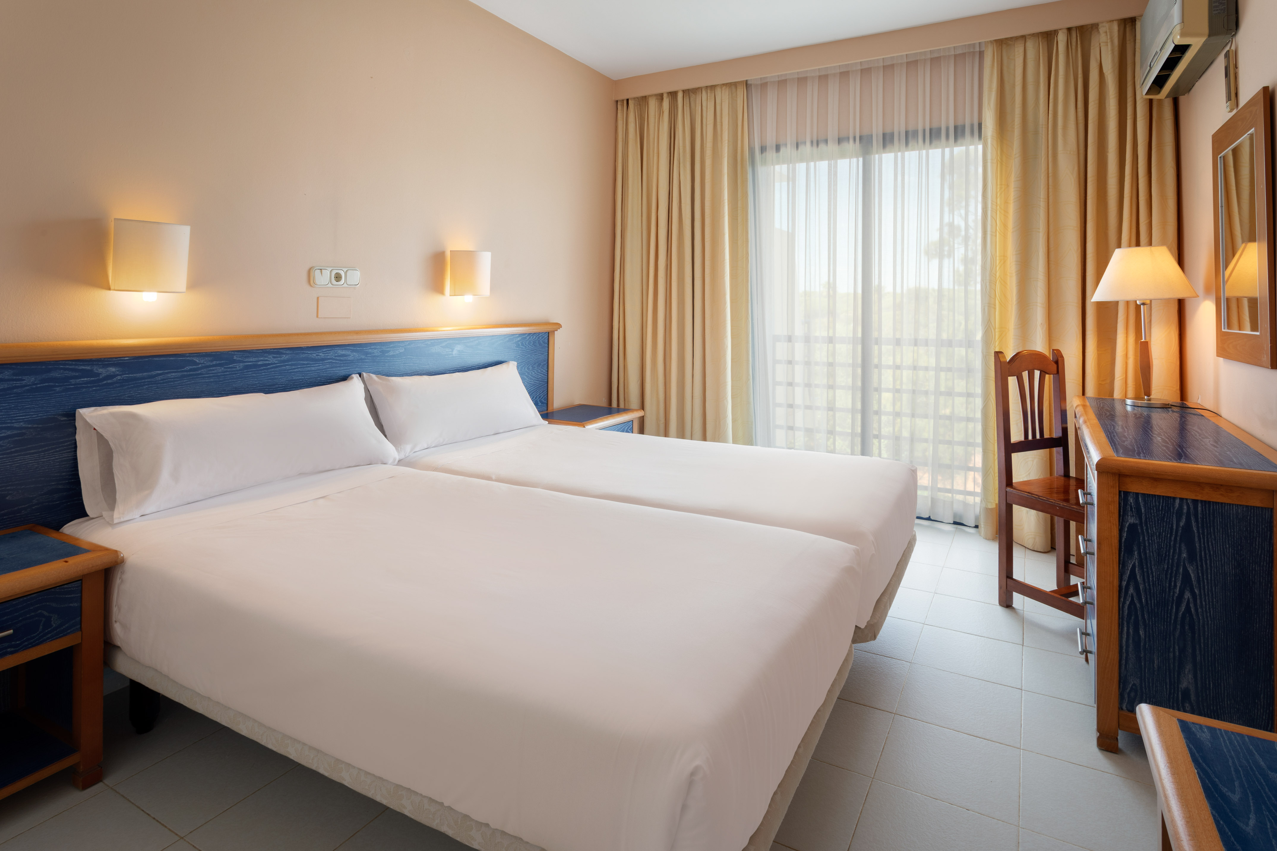 a room with two beds and a chair