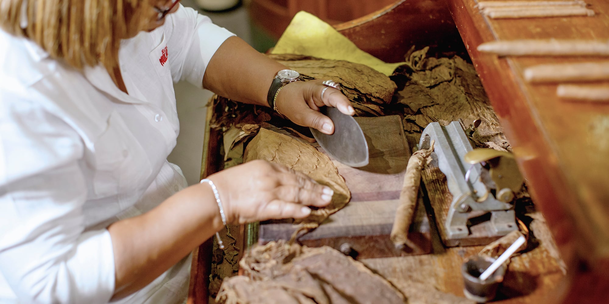 a woman cutting a cigar