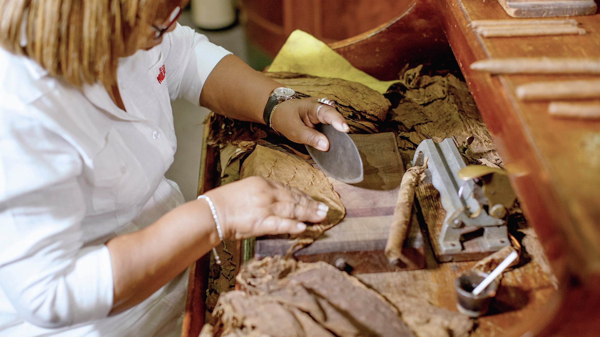 a woman cutting a cigar