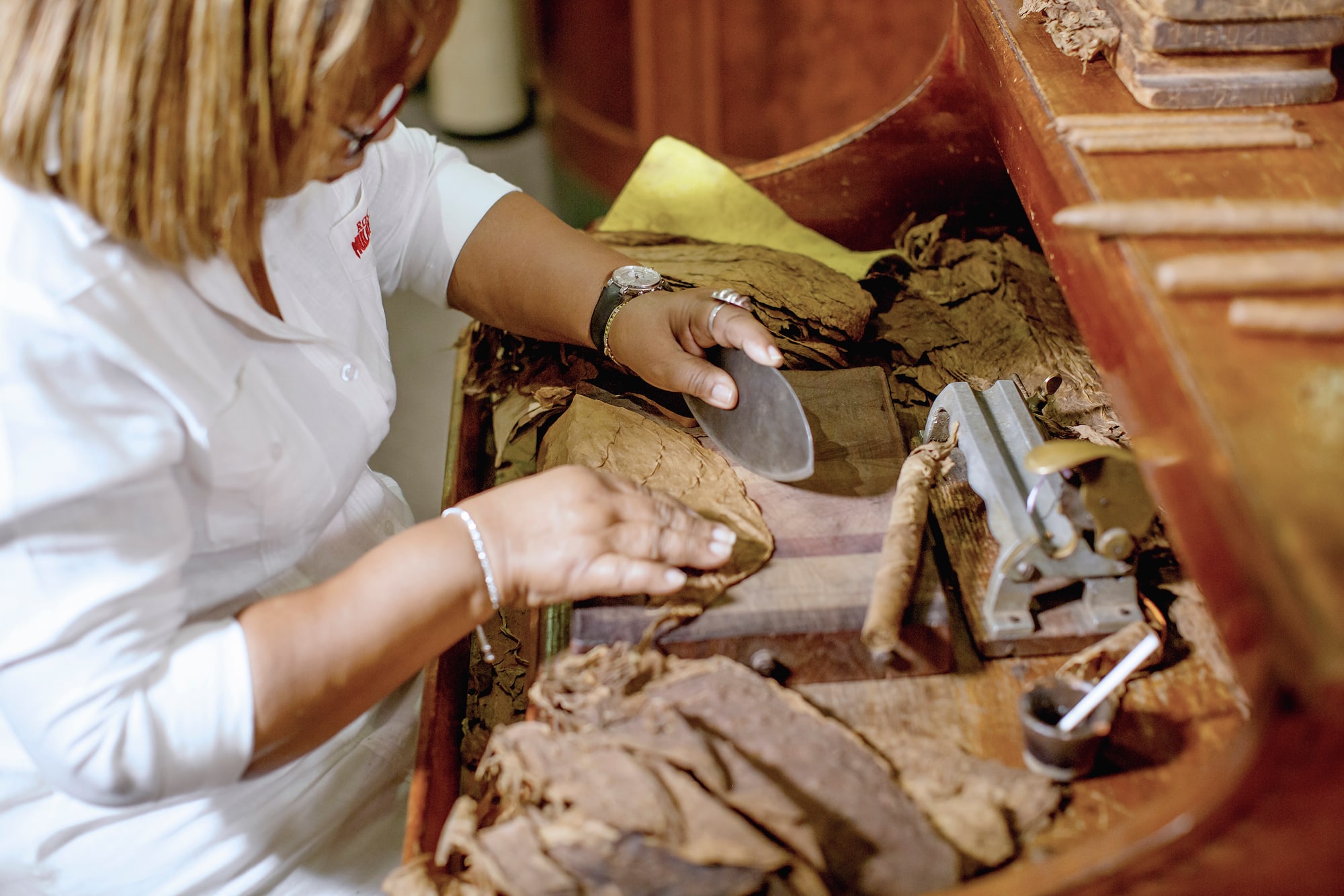 a woman cutting a cigar