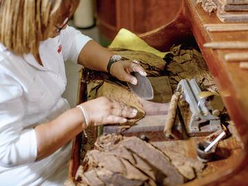 a woman cutting a cigar