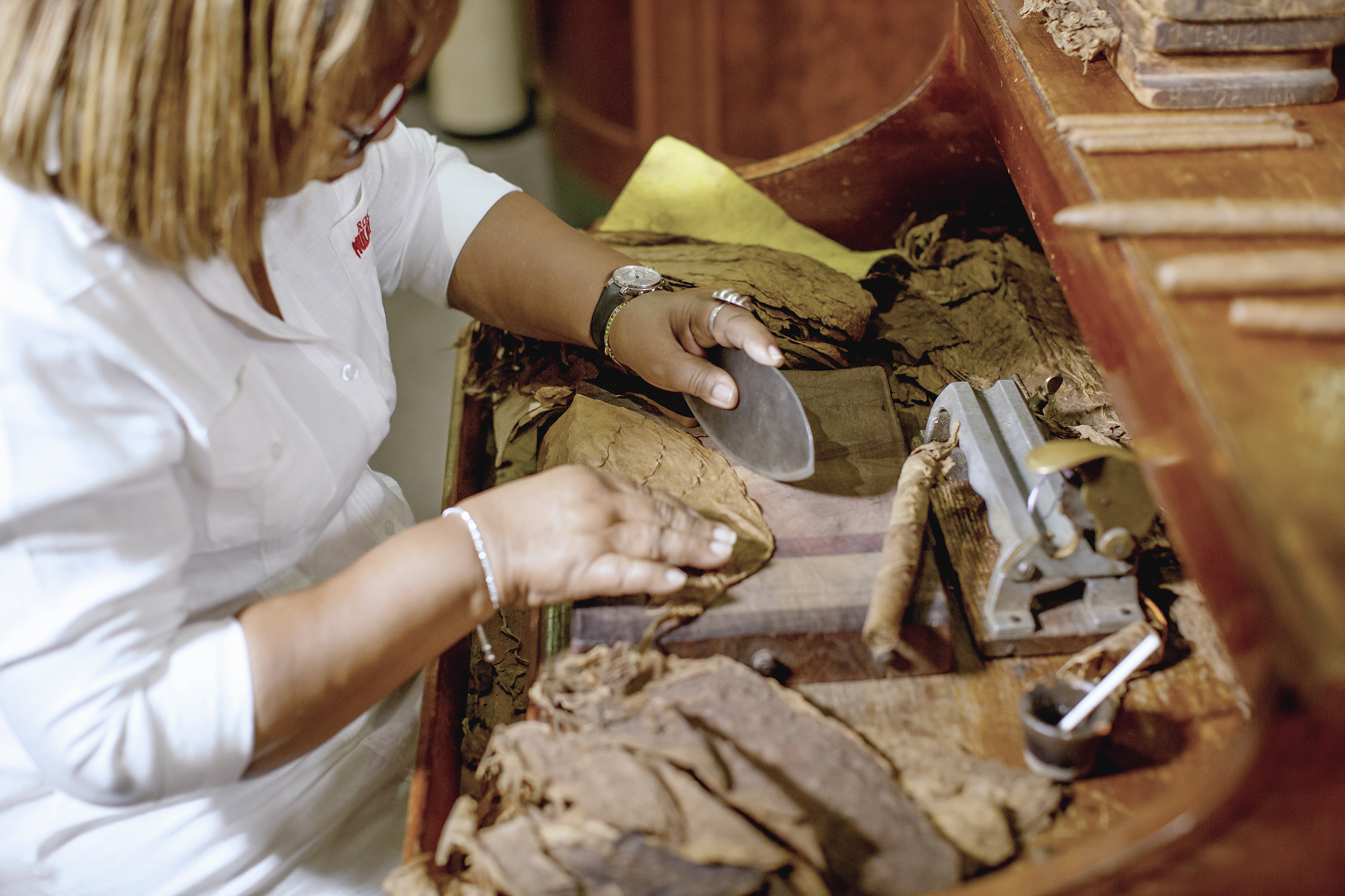 a woman cutting a cigar