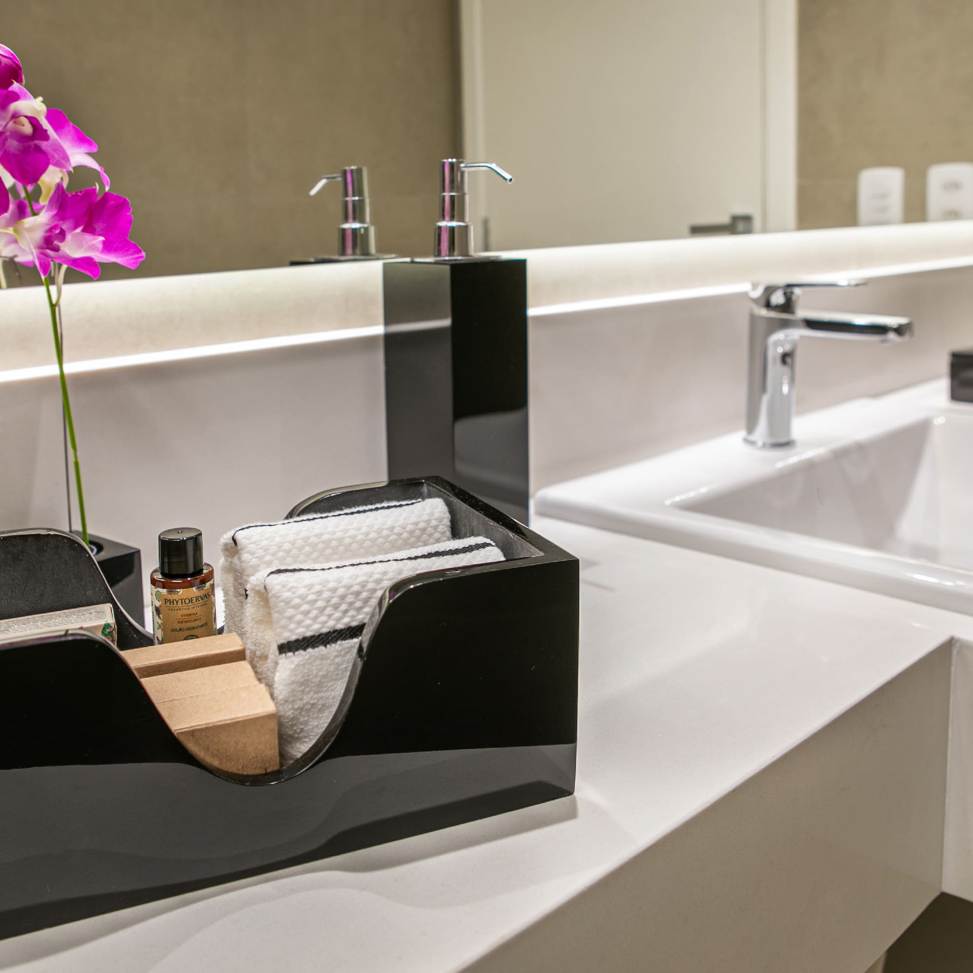 a black and white bathroom sink with a flower in a black box