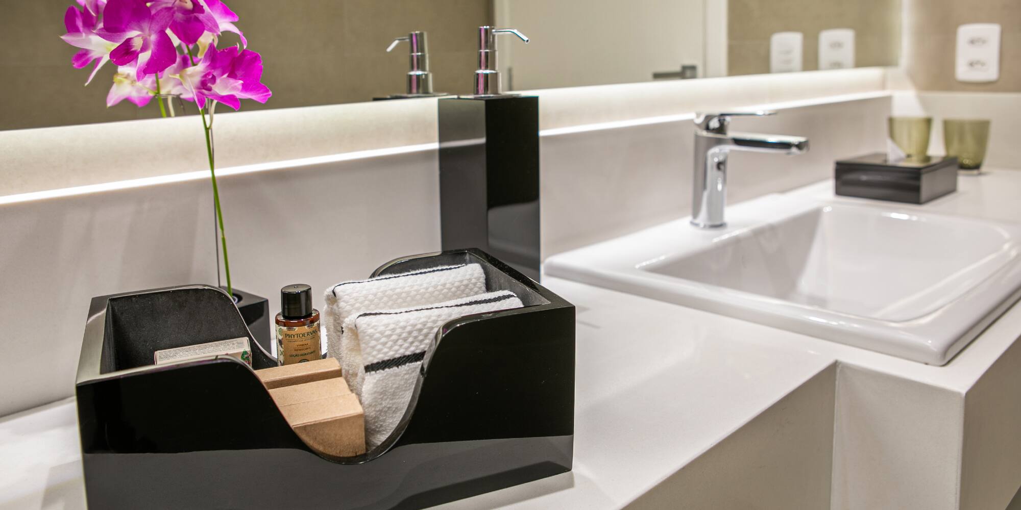 a black and white bathroom sink with a flower in a black box