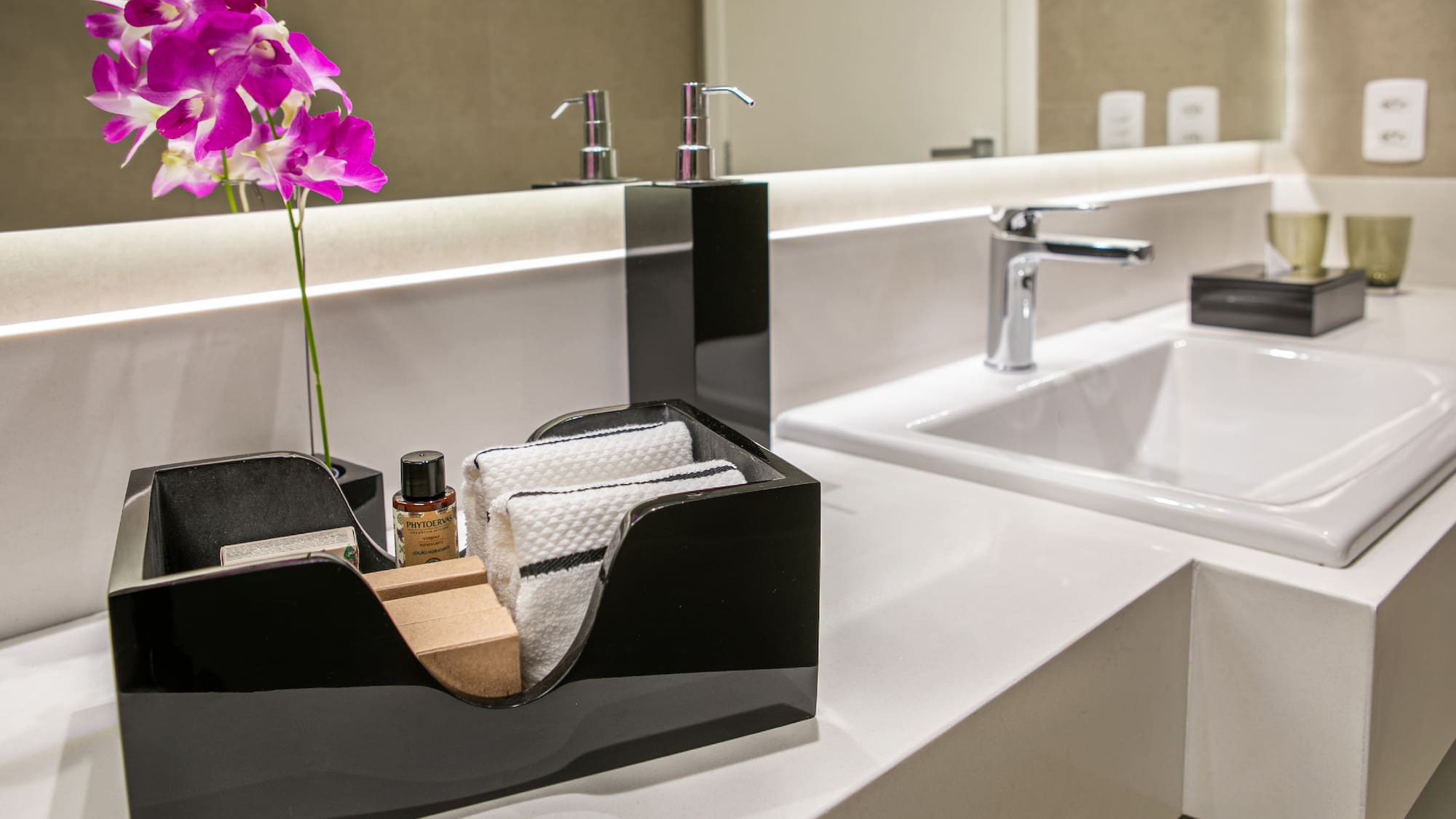 a black and white bathroom sink with a flower in a black box
