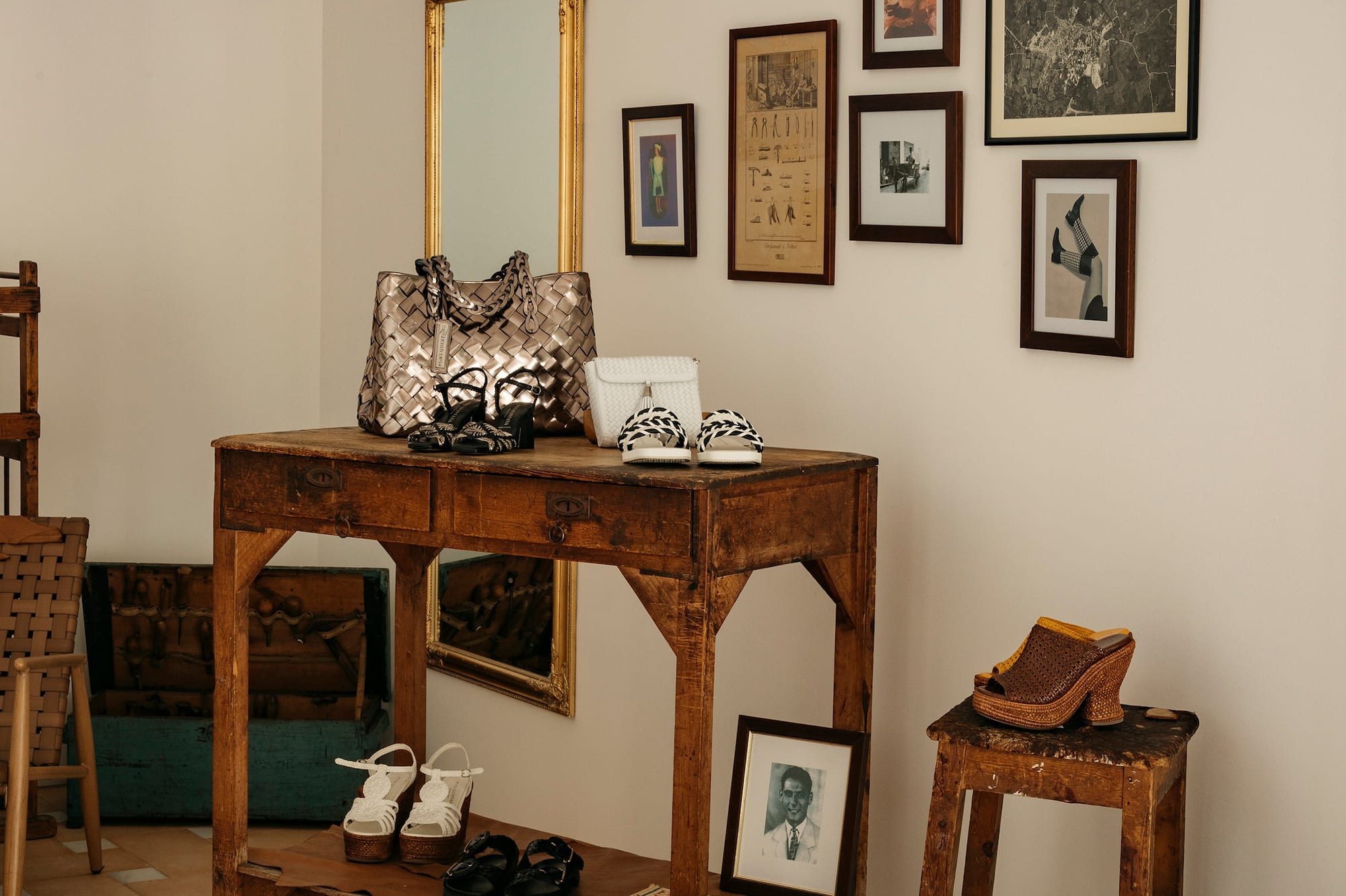 Rustic boutique footwear display: woven bags, sandals, boots, vintage furniture, wall art.