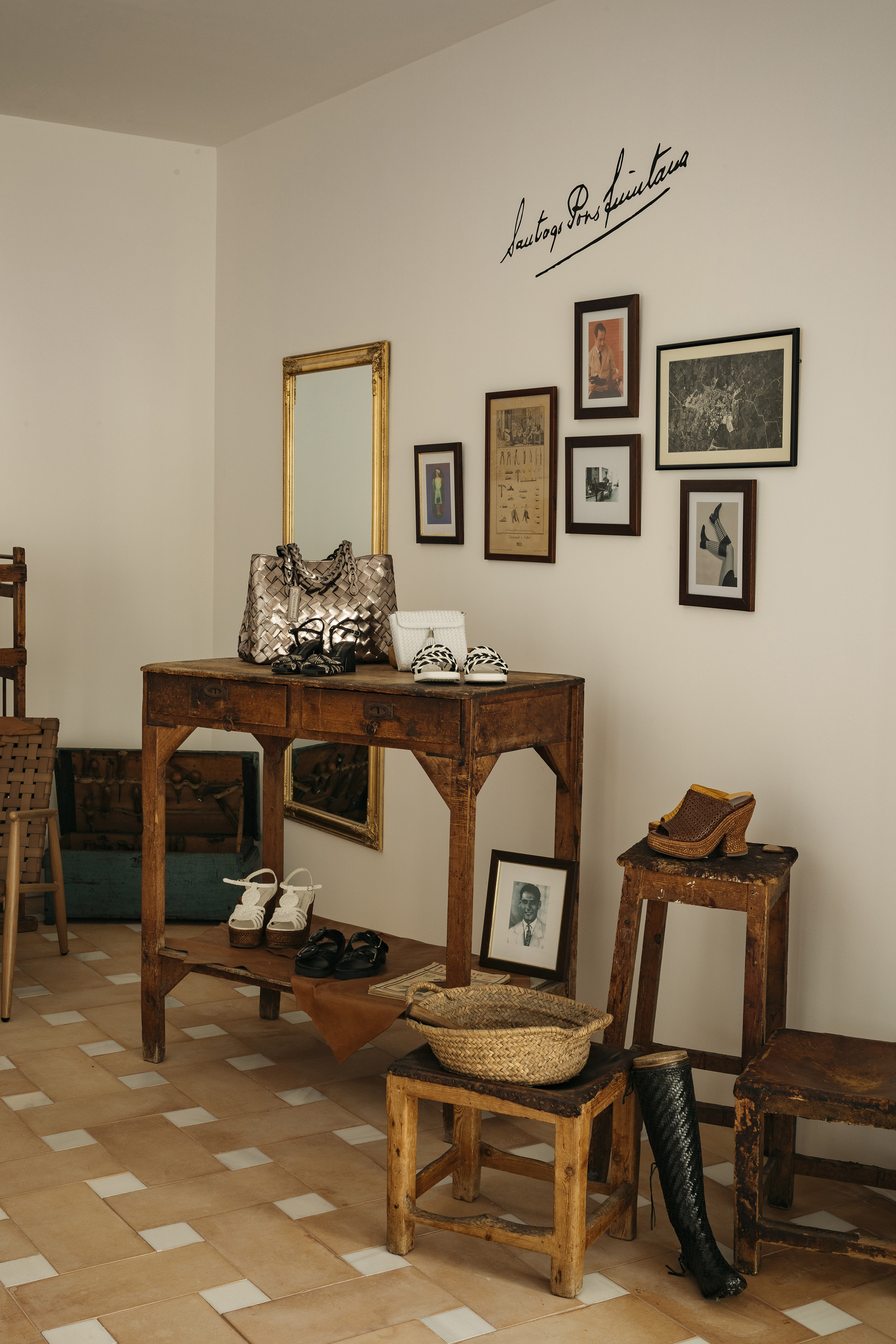 Rustic boutique footwear display: woven bags, sandals, boots, vintage furniture, wall art.