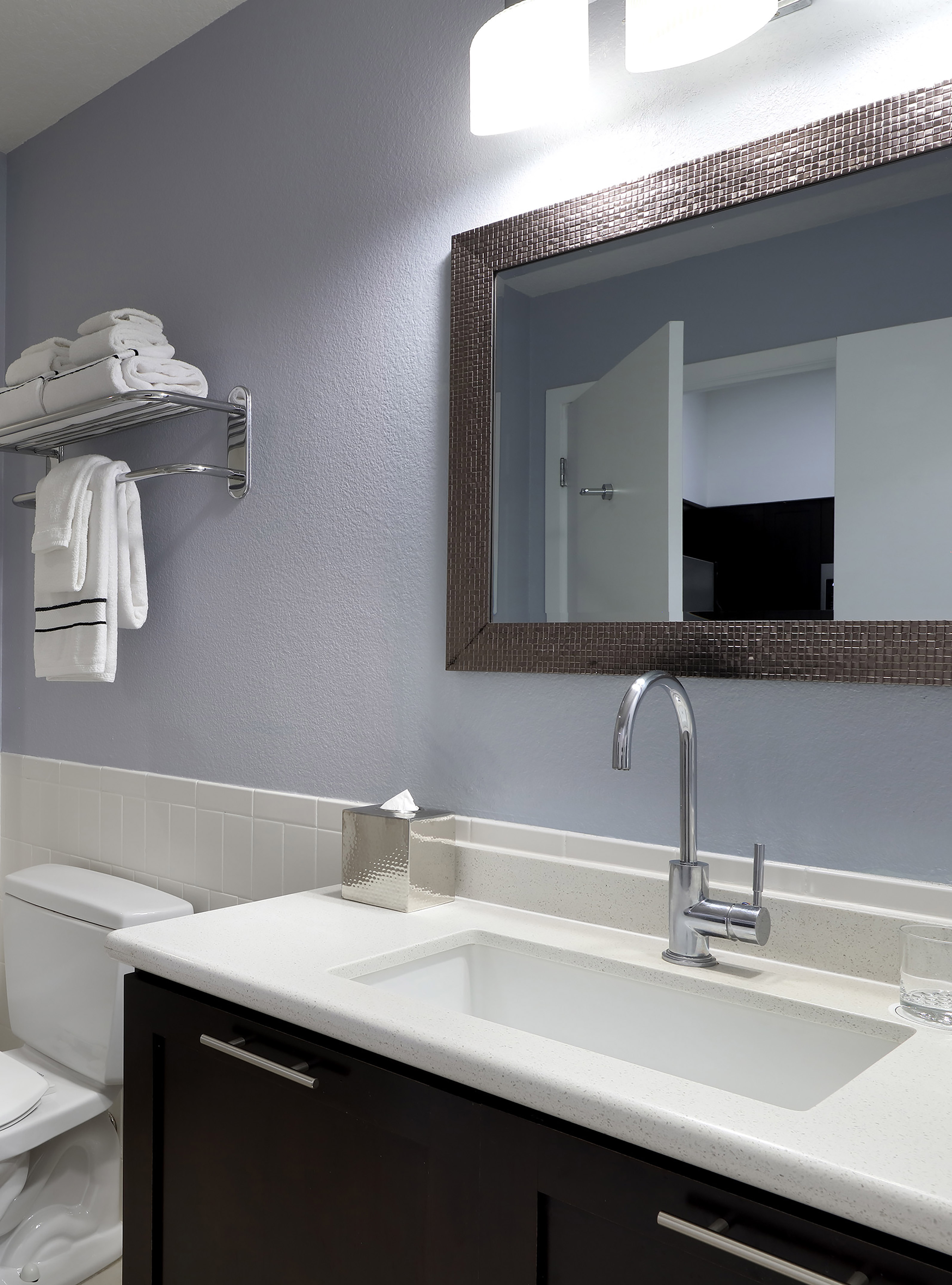 Modern bathroom with white sink, dark vanity, mirror, toilet, and fresh towels. - Accessible Room - Meliá Orlando Celebration, Orlando