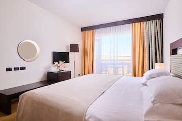 a bed with a lamp and a mirror in a hotel room