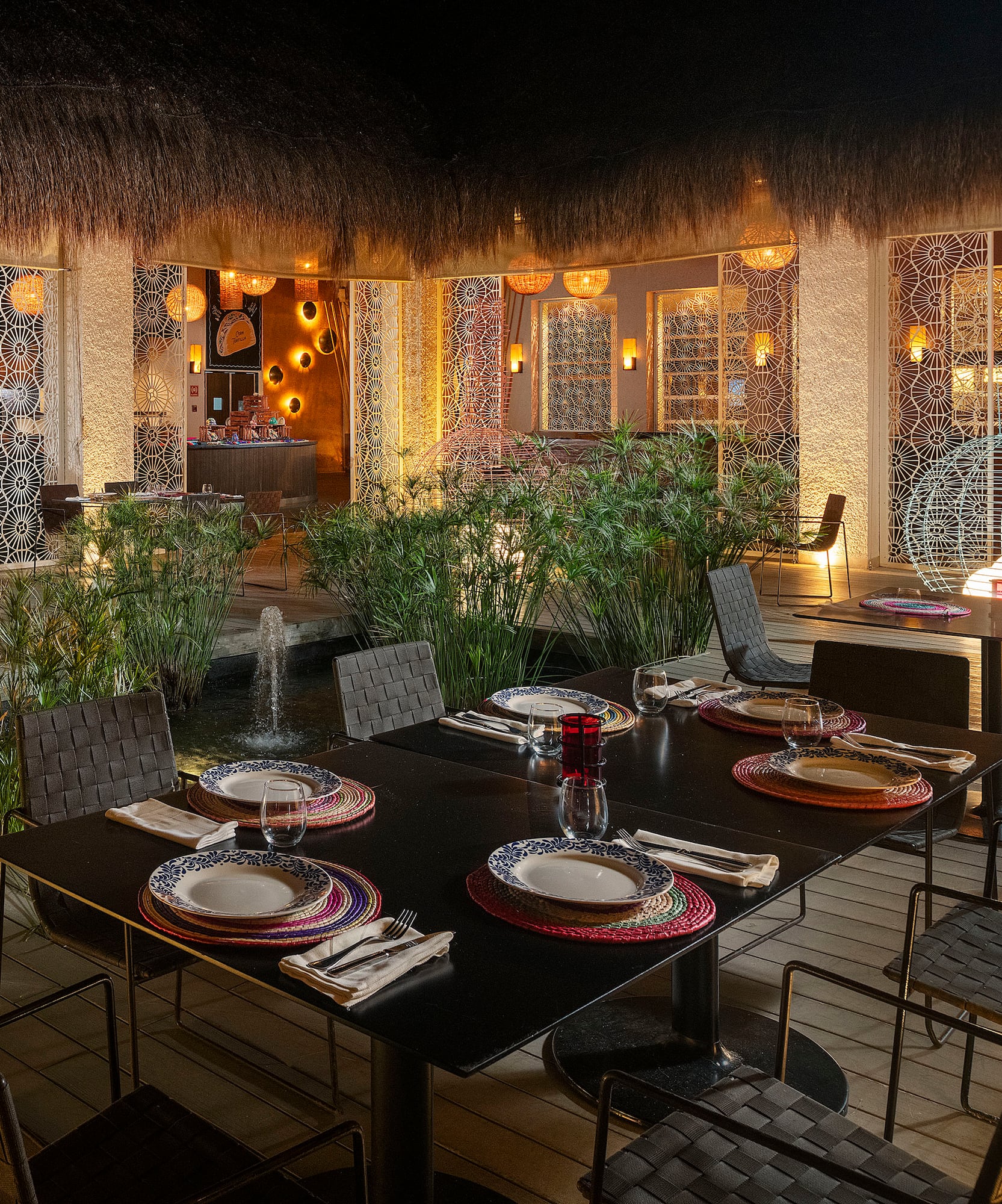 a table set for dinner with a fountain in the background