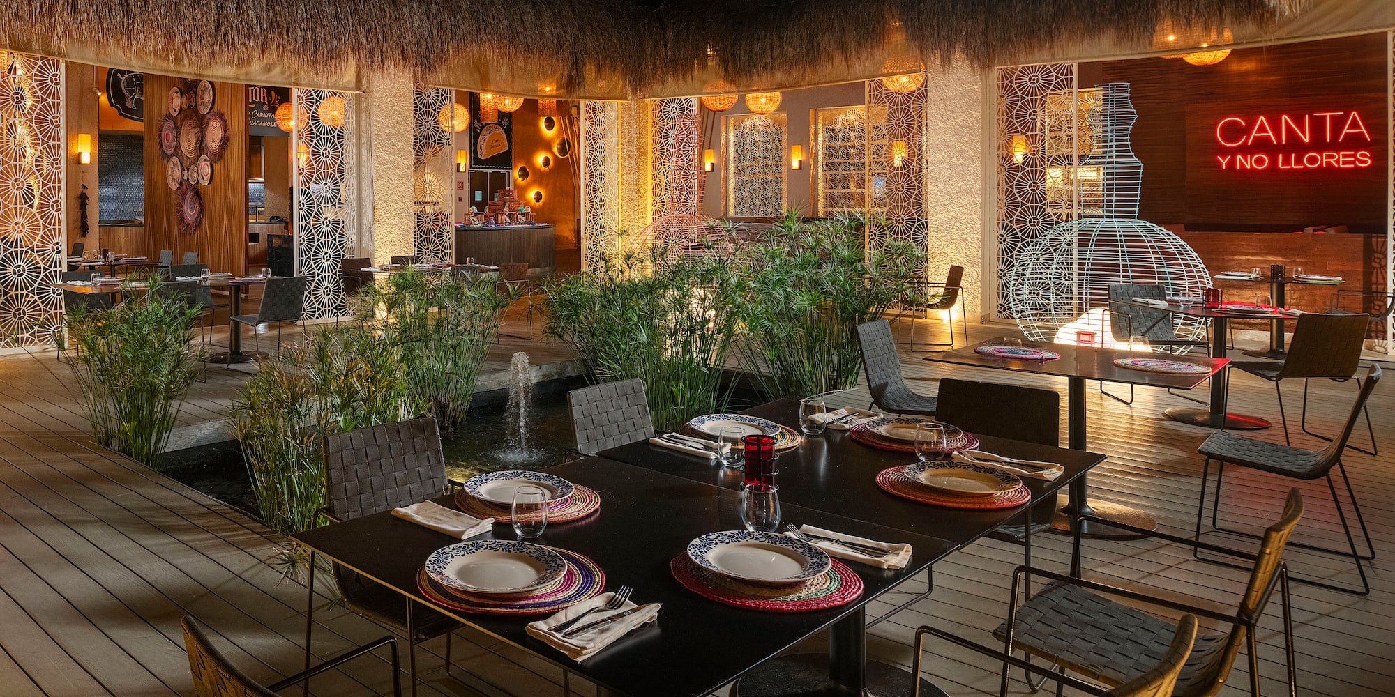a table set for dinner with a fountain in the background